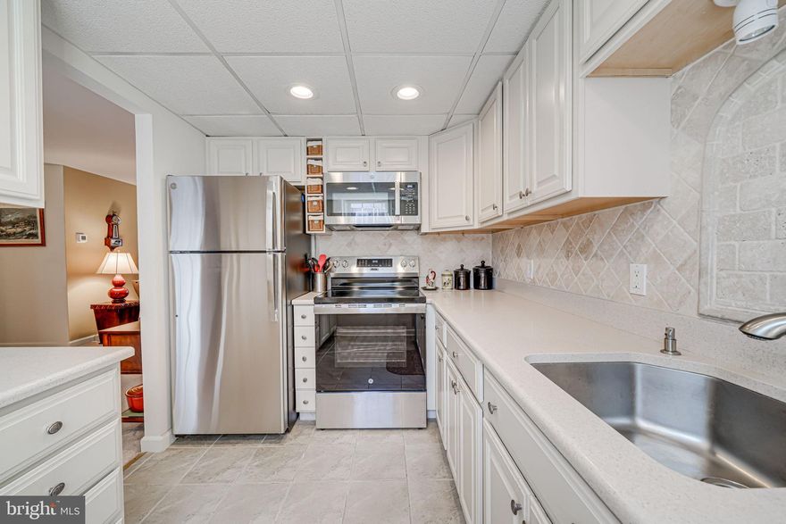 Welcome to 4869 28th St S #B2, a rare Ashlawn 2 model in the highly sought-after Fairlington Villages community—one of only 18 in the entire neighborhood! This meticulously maintained 2-bedroom, 1-bathroom condo offers a blend of charm, modern updates, and unbeatable location.

Up one flight of stairs, you’ll enter a naturally bright and open living space, where tall ceilings and a neutral color palette enhance the home’s spacious feel. The inviting living room, featuring a decorative faux fireplace, seamlessly flows into the dining area with direct access to a large private balcony—perfect for enjoying morning coffee or evening relaxation.

The chef’s kitchen has been thoughtfully updated with brand-new stainless steel appliances (March 2025), quartz countertops, a timeless backsplash, and white cabinetry with ample storage. Recessed lighting and natural sunlight create a bright and welcoming atmosphere. A deep coat closet near the front entrance and an additional spacious storage closet—ideal as a pantry—provide generous storage solutions.

The primary bedroom comfortably fits a king-size bed and large furniture and is complete with a ceiling fan and two closets. The second bedroom is also spacious with dual closets. The well-appointed bathroom boasts an extended vanity with granite countertops and a linen closet for extra storage.

One of the standout features of this home is the incredible storage options, including a fully floored and insulated attic and a private storage room (16’6” x 8’6”) in the basement level of the same building. Additional recent upgrades include a brand-new washer and dryer (March 2025), a newly updated water heater located in the storage unit, and replaced water shut-off valve and plumbing. The condo association is set to renovate the building’s hallway in summer 2025.

Fairlington Villages offers a vibrant community lifestyle with access to pools, multiple tennis courts, and beautifully maintained green spaces. The condo fee of $425 per month includes water/sewer, exterior maintenance, landscaping, and access to community amenities. Parking is convenient with one primary permit and one secondary permit.

Located just minutes from Shirlington Village, the Bradlee Shopping Center, and the new West Alex development, residents enjoy a variety of dining, shopping, and entertainment options. The nearby W&OD Trail, Barcroft Park, and Fort Ward Park provide excellent outdoor recreation opportunities. Commuters will appreciate the easy access to I-395, Route 7, and Route 50, making trips to Pentagon City, Crystal City, Amazon HQ2, and downtown D.C. a breeze. Public transportation options are plentiful with Metrobus routes nearby, and the Pentagon and Ballston Metro stations just a short drive away.