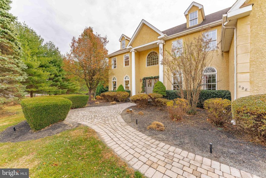 A stunning, well-maintained home in one of Media’s most desirable neighborhoods! Nestled on a private, tranquil driveway off Old Forge Rd, this home thoughtfully designed and maintained. Offering elegant details throughout, including elevated ceilings, crown molding, custom built-ins and cabinetry, expanded closets, and spacious living areas, it is a true standout. Upon arrival, you are greeted by a professionally landscaped, pillar driveway that leads to a grand entryway. Two-story columns frame the oversized arch window and double doors. Inside, the two-story foyer with marble floors and curved wooden staircase, creates a dramatic first impression. It is further enhanced by the double crown molding and natural sunlight. To the left of the foyer, the formal living room features crown molding, curved windows, and a gas fireplace. On the right, the dining room is equally impressive with newly refinished hardwood floors, wainscoting, and curved windows. A powder room sits upon entering the living room. Straight through the foyer, a powder room on the right, you will find the heart of the home - a sundrenched, two-story family room. A wall of windows allows for the south-facing room light to enter, and views directly to the backyard. The gas fireplace adds warmth and charm. Adjacent to this, a secluded den with French doors and hardwood floors offers the perfect space for office or playroom. The gourmet kitchen features granite countertops, a secondary sink, custom hardware, Perrin & Rowe fixtures, and GE Cafe appliances. Ample cabinetry provides excellent storage and a hidden back staircase leads to the upper level. A cozy kitchen nook with French doors opens to the expansive limestone patio ideal for al fresco dining. Or relaxing by the fire pit, all overlooking the pool and backyard. Adjacent to the kitchen is the mudroom with custom cabinetry, adequate closet space, and access to the attached, three-car garage, as is a secondary powder room. Upstairs, you will find 4 generously sized bedrooms and 3 bathrooms. The expansive primary suite offers a private, front living room with hardwood, custom tray ceilings, new carpeting, a large walk-in closet with a laundry room. Two additional closets - all include custom closet cabinetry. The en suite bath includes a marble-clad jacuzzi tub, walk-in shower, and designated vanity. The second bedroom includes hardwood floors, a walk-in closet with custom cabinetry, and a sunlight bathroom. The third and fourth bedroom share a jack-and-jill bathroom. The third bedroom also features hardwood floors and a walk-in closet with custom cabinetry. The fifth floor is grand and unexpected; its expansive area offers a large walk-in closet and private bath - making a wonderful guest space. The finished basement offers a grand, open area for gathering and entertaining. A wine cellar, movie theater, playroom with custom cabinetry, a fifth bathroom and secondary kitchen with custom oak cabinetry and granite countertops provide the perfect space to host. French doors lead to the secluded back patio and path to the main backyard. The serene backyard is perfect for al fresco dining, grilling, relaxing, and swimming with the salt-water pool. The fully equipped outdoor kitchen includes a sink, disposal, grill, gas burners, and granite countertops. Pristine gardens with hydrangeas, wisteria, and lavender add beauty and color throughout the seasons. This home combines tranquility with easy access to every convenience - within minutes of local parks, shopping, public transportation, and the quaint town of Media. Zoned for award-winning Rose Tree Media School District and close to several private schools.