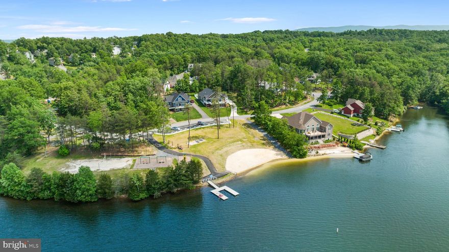 Rarely does a property of this quality and location come to market. This spectacular residence occupies one of Lake Holiday’s most distinguished addresses within the highly exclusive Sleigh Drive enclave—just fifteen homes in total AND the only location in Lake Holiday that offers direct beach access from your doorstep.
Tucked against hundreds of acres of wooded trails and the quieter, newly improved South end of the lake, the setting is private, serene, and unlike any other within the community.

Only steps away, **Beach Two** offers a sandy swimming area, playground, summer camp space, and convenient boat launch with docks. From the home, enjoy water views—some seasonal, others enduring—providing a constant reminder of the lake’s natural beauty.

Built in 2006, the home has been beautifully renovated with a thoughtful balance of sophistication and comfort. The chef’s kitchen boasts a professional G.E. Café six-burner range, new countertops, flooring, and appliances. Renovated baths, including a refreshed primary suite, showcase timeless style, while period Danish Modern lighting fixtures lend a touch of design-forward character.

All major systems have been updated, including dual-fuel HVAC with heat pumps and a Rinnai tankless water heater. Outside, a new deck and a fully fenced backyard expand the living space for gatherings or quiet enjoyment.

**2023 Upgrades & Enhancements:**

* Renovated primary suite & half bath
* New kitchen appliances, countertops & flooring
* New HVAC & tankless Rinnai water heater
* Updated lighting & ceiling fans
* Plantation shutters & custom blinds
* Fully fenced backyard & new deck
* Additional improvements throughout (full list available)

Life at Lake Holiday offers more than a home—it provides a lifestyle. Residents enjoy the security of a 24-hour gated community and access to a clubhouse, fitness center, parks, three sandy beaches, and a welcoming lake culture.
Located a short drive from Old Town Winchester, Winchester Medical Center, and 75 minutes from One Loudoun