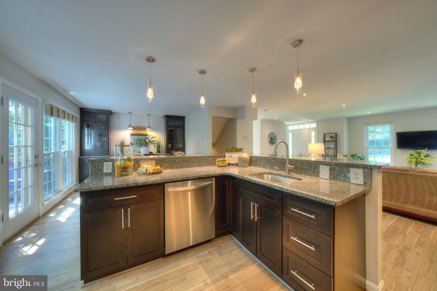 Beautifully remodeled end unit backing to greenspace.  4 levels, 3.5 baths. Gorgeous renovations on main level -- Wall  removed, resulting in an open and versatile floor plan.  Luxury kitchen with huge l-shaped center island,  plus a full wall of additional cabinetry, a wet bar and wine frig.  Lovely wood flooring.  Deck off the kitchen with stairs to yard enhances the entertaining space.     Upper level features three bedrooms, lovely renovated hall bath.  Primary features vaulted ceilings, and loft  --- don't miss the huge storage area there.   Walkout lower level with fireplace is light and spacious. A full bath, a "den", and storage room completes this level.   Unbeatable location -- walk to North Point Village Center,  Tennis, Pools and Trails.   10 min. from Dulles Airport.  Make this your home and enjoy the Reston Lifestyle!