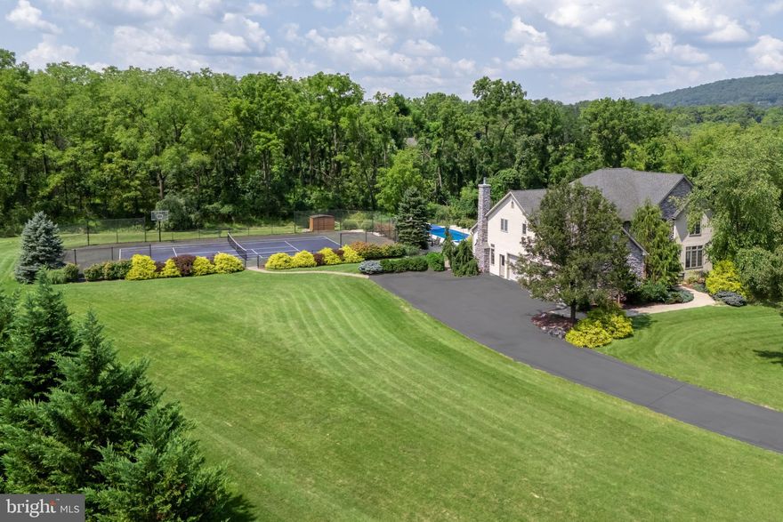 Welcome to this spectacular 4-bedroom, 5-bathroom home, a haven of luxury and comfort nestled on a quiet cul-de-sac sprawled across 2 acres of lush land. Step into the grand two-story foyer where sunlight floods through, highlighting beautiful details that define the essence of this home. For the culinary enthusiast, the gourmet kitchen offers high-end appliances, custom cabinetry, and a sizable center island—a perfect hub for family gatherings and casual breakfasts alike. The formal dining room and living room provide elegant spaces for entertaining, while the home office offers a serene environment for work or study. The primary suite is a true retreat, boasting a spacious layout, a luxurious en-suite bathroom, and dual walk-in closets with built-in systems for optimal organization. Each of the other three bedrooms offers generous space, en-suite bathrooms, and ample storage. And a beautifully finished lower level with half bath is a great spot to enjoy. Outside, discover your private sanctuary with an inviting in-ground saltwater pool and spa, ideal for relaxation and hosting memorable get-togethers. Two pergolas offer shaded spots for alfresco dining and lounging, creating the ultimate backdrop for family and friends to come together. Sports lovers will appreciate the pickleball/tennis court, ensuring endless fun and fitness right at home. With lovely grounds and serene surroundings, this property offers a fabulous lifestyle in a peaceful setting.