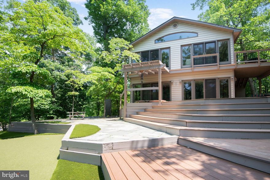 Stunning contemporary in Winchester on the Severn featuring abundant windows that provide private treetop views.  Situated at one of the highest elevations, the property is surrounded by parkland and overlooks wooded areas. Enjoy multi-level decks, stone patios, and custom hardscaping, complete with a private putting green and hot tub.  Main level includes foyer, large sunroom, living room with stone fireplace - dining room combination, kitchen with granite countertops, main bedroom with adjoining full bath, 2 additional bedrooms and full bath in hall.  The lower level includes another sunroom with exit to the  rear yard, recreation room, office/potential 4th bedroom, and another very spacious room / potential 5th bedroom with super bath and side exit.   A real beauty!

The Winchester on the Severn community offers a voluntary association fee of $260 per year for access to amenities, including a private beach, dock, canoeing, playground, and covered picnic pavilion .  The community also  has 2  different areas with boat slips that when available can be rented for an additional fee.   The Chase Creek Swim Club  is also nearby and joinable for an additional fee.