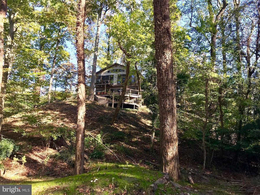 Stunning contemporary home in Winchester on the Severn featuring abundant windows that provide private treetop views.  Situated at one of the highest elevations, the property is surrounded by parkland and overlooks wooded areas. Enjoy multi-level decks, stone patios, and custom hardscaping, complete with a private putting green and hot tub. The community offers a voluntary association fee of $260 per year for access to amenities, including a private beach, dock, boat slips, canoeing, and a beach club. The Chase Creek Swim Club is also nearby.  A true gem!
