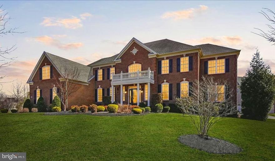 Where timeless architecture, grand scale, and resort-style living come together in the prestigious, gated Oak Creek Club Golf Community.  This exceptional Toll Brothers residence sits prominently on a corner lot and showcases a striking brick façade, stately portico entry, architectural rooflines, and a side-entry three-car garage surrounded by lush landscaping and elegant hardscapes. Inside, a breathtaking two-story marble foyer with dramatic curved dual staircases, crystal chandelier, and Romeo and Juliet balconies sets an unforgettable tone. Rich hardwood floors, bespoke moldings,  and designer lighting create a seamless blend of elegance and comfort throughout.  Designed for both grand entertaining and comfortable everyday living, the main level showcases formal living and dining rooms, a striking conservatory or piano room, private study, and an impressive two-story great room with gas fireplace, halo chandelier, coffered ceiling and Sonos Sound.   The chef’s kitchen is beautifully appointed with GE Monogram appliances, including a professional gas range with six burners, griddle, and double ovens, an additional wall oven and microwave, granite countertops, rich cabinetry, and a dramatic 11-foot center island with prep sink.  A custom walk-in pantry provides exceptional storage, while the kitchen flows seamlessly into the sun-filled Naples room with vaulted ceilings and screened porch overlooking picturesque views.  A private elevator provides convenient access to all three finished levels of the home. Upstairs, four spacious ensuite bedrooms include a luxurious primary retreat with sitting room, dual walk-in closets with custom built-ins, and a spa-caliber bath featuring marble vanities, soaking tub, an oversized multi-head shower and 2nd private sitting area. The expansive walkout lower level is an entertainer’s dream, featuring a private theater, custom wet bar, recreation and gaming areas, fitness studio, additional bedroom, and 5th full bath. This versatile space is ideal for guests, an au pair suite, or multi-generational living.  The sun-filled lower level opens to an expansive patio with a grilling station, fire pit, and multiple gathering areas. Residents enjoy premier amenities within this gated community, including tennis courts, a clubhouse, pool, walking and biking trails, and an 18-hole championship golf course. Ideally located just minutes from Annapolis, the DC line, and major commuter routes.  Conveniently located near Bowie Towne Centre with easy access to major commuter routes and the DC line. Enjoy proximity to Washington, D.C.’s world-class dining, cultural attractions, sightseeing, and upscale retail, along with Maryland’s renowned National Harbor, Baltimore’s Inner Harbor, and historic Annapolis. A rare offering where timeless architecture, modern luxury, and resort-style living come together beautifully—an exceptional place to call home.