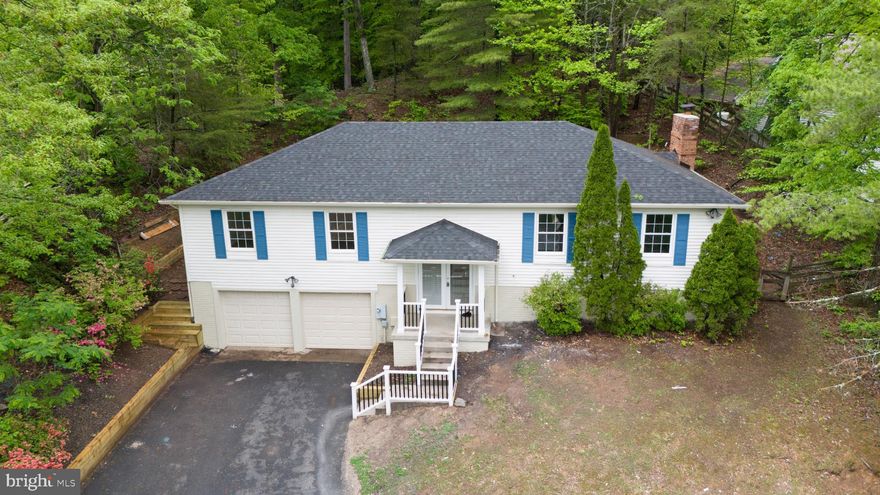 Welcome to this beautifully remodeled 5-bedroom, 3-bath custom home offering over 2,800 sq ft of living space, nestled on a quiet 0.56-acre wooded lot with winter views of Quantico Creek Bay. Move-in ready and loaded with upgrades, this home combines comfort, privacy, and convenience. The main level features a bright, open layout with 3 bedrooms and 2 full baths—ideal for both everyday living and entertaining. The modern kitchen showcases new sleek countertops, stainless steel appliances, and stylish finishes throughout. The fully finished lower level offers incredible flexibility, including 2 additional bonus rooms perfect for bedrooms, home offices, or guest space, along with a full bath, and a spacious rec room complete with a cozy fireplace. Recent improvements include a new roof, remodeled bathrooms, fully remodeled kitchen with updated stainless steel appliances, luxury vinyl plank flooring, fresh paint, new deck, and a fully updated front yard featuring a new retaining wall. Step outside to a brand-new deck overlooking a serene, tree-lined backyard—perfect for relaxing or hosting. A spacious 2-car garage provides ample storage, and the prime location puts you just minutes from Quantico Base, I-95, VRE, shopping (Potomac Mills Mall, IKEA, Stonebridge Potomac Town Center, Dumfries Town Center, Wegmans), parks, and trails. This home has it all—modern updates, generous space, wooded privacy, and unbeatable convenience!