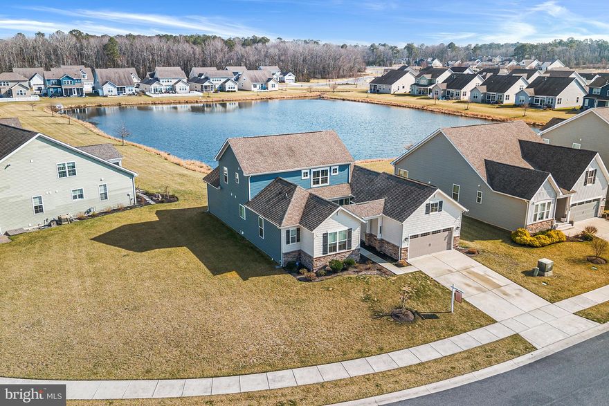 Located in The Estuary community and backing directly to a large scenic community pond, this meticulously maintained 5-bedroom, 3-full-bath home offers a spacious open floorplan filled with abundant natural light. The inviting living room flows seamlessly into the upgraded eat-in kitchen featuring a large island, stainless steel appliances, under-cabinet lighting and a pantry, with easy access to the enclosed porch and large stone patio—an ideal place to relax while enjoying peaceful private pond views. The main level includes a beautiful primary bedroom with a tray ceiling and a luxurious ensuite bathroom, along with two additional bedrooms and a second full bath on the opposite side of the floor for added privacy. A well appointed mudroom and laundry room complete the main floor. Upstairs, a spacious loft provides flexible living space perfect for a sitting room or home office. The upper level also features the fourth and fifth bedrooms, including one with its own private ensuite bath, making it an ideal guest suite. The two-car attached garage features an electric car charger and ceiling storage unit. Additional features include solar panels, producing a nominal electric bill! Additionally, enjoy LED lighting throughout the house, including exterior landscape lights, plus a camera system and whole house water filtration system. This thoughtfully designed home combines comfort, space, and a tranquil setting in a sought-after community. Mortgage savings may be available for buyers of this listing.