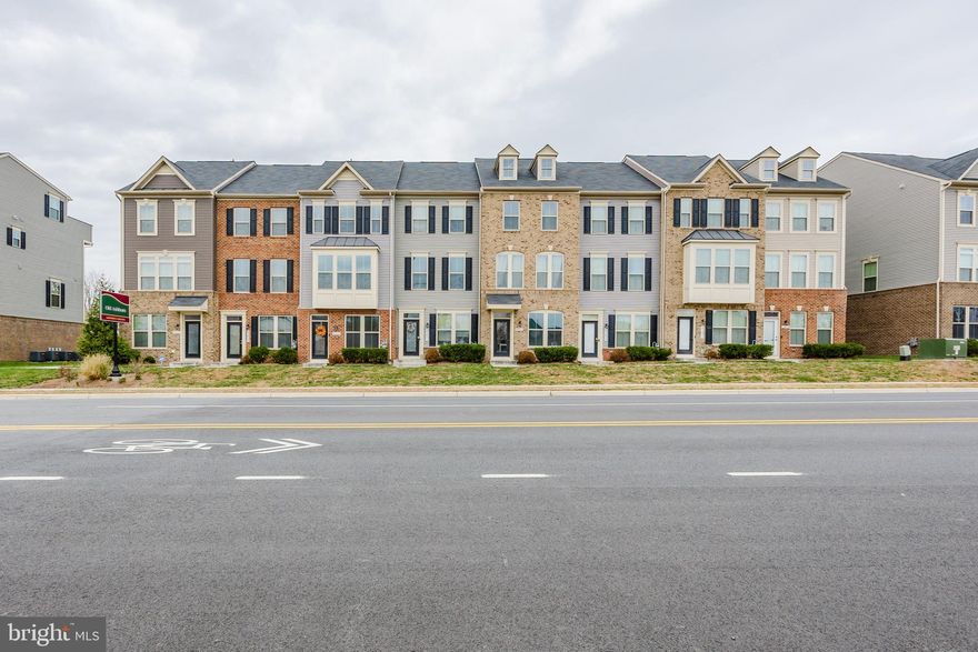 Welcome to this modern 3-bedroom, 3.5-bath, four-level townhome located in the highly desirable Trailside community of Ashburn (Loudoun County). Enter through the rear two-car garage into a welcoming foyer, then ascend to the main level featuring an open-concept living and dining area with large sliding glass doors that flood the space with natural light and lead to a private deck. The chef’s kitchen boasts stainless steel appliances, a center island, and ample counter and cabinet space. Upstairs, the third-level hosts a spacious primary suite with a generous walk-in closet and its own full bath, along with a secondary bedroom and another full bath. The top floor is a flexible bonus space that could function as a guest retreat, home office, or recreation room; it also features a full bath and a rooftop deck. Finished with modern touches throughout, this home offers central air conditioning, electric heat, and hot water. The community provides easy access to the W&OD  trail, is near major commuter routes (Route 7, Dulles Toll Road), and is just minutes from shopping, dining, and transit options. This well-maintained townhome offers a desirable blend of style, functionality, and convenience.