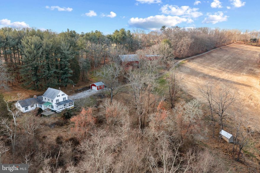 TRUST YOUR INSTINCTS. Discover the undeniable allure of country living on 58+ acres with tillable fields, pastureland, and streamside walking and riding trails only minutes from bustling Hunt Valley. Three parcels convey. Opportunity abounds as you determine how you will be inspired by the land and the structures that exist. Possibilities are endless. Outbuildings include a historic bank barn, stone root cellar and springhouse, and a huge machine shed for farm equipment or a car aficionado’s collection. The circa 1912 farmhouse with updated windows features charming and original living and dining rooms with wood floors. A large great room addition serves as the central hub for gathering with both wood burning fireplace and wood burning stove adjacent to a country kitchen with spacious breakfast room. The main level primary bedroom wing connects to a main level laundry. The second level offers 3 bedrooms, all with double closets and a shared full bath. A finished attic serves as a play area or home office with abundant storage. Both formal rooms and the great room open to a large wraparound enclosed brick porch offering scenic vistas where eagles rise from golden pastureland and towering native woodlands. Relish the seasons exploring wildlife habitats. Outdoor enthusiasts are drawn to the region known for steeplechase, biking, and hunting. The property is sold in As-Is Condition, and the Seller cannot make repairs. Property is served by a spring and a well does not exist.
