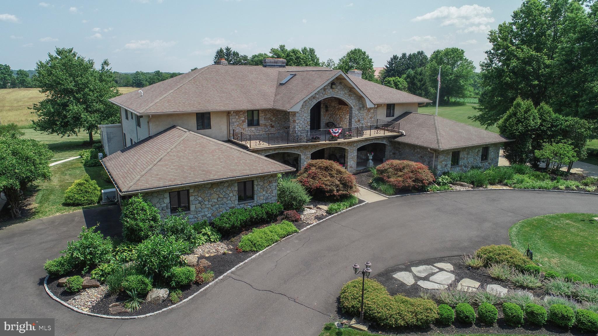 DRASTIC PRICE DROP AND OWNER WILL FINANCE THIS MAGNIFICENT HOME! Enter through the wrought iron gates of this beautiful villa style residence and know at once that a comfortable living environment has met elegant architecture and design. Surrounded by preserved open space you can be certain that the lovely views from each window will stay the same for years to come. The impressive grand entry showcases a graceful butterfly staircase leading to the carefully conceived floor plan featuring 4 large bedrooms on 2 separate, distinct wings of the house. This unique home is perfect for a multi generational living situation. The expansive common living areas begin with the heart of the home, The kitchen. Clearly created for people who LOVE to cook and EAT, this kitchen is outfitted with every top of the line feature imaginable, truly too numerous to list. The raised hearth wood burning fireplace creates a cozy, warm environment for this extraordinary gathering place. The 1st floor master suite includes an expansive bedroom with its own private sunroom attached, perfect for the morning workout, a fireplace framed by nicely trimmed closet storage, a huge walk-in closet and luxurious spa style bath. The lower level features an expansive recreational area, billiards room, a fully equipped bar with every bell and whistle, and a second kitchen. Again a wonderful set up for a multigenerational family. The mechanicals of this extraordinary home have been updated with 400amp service, a full house generator, gas radiant or cast iron hot water heating by a Dankirk high-end boiler, central dehumidifier and 6 zone heat (5 zones for central air conditioning). This unique property is very easy to show and our absolute pleasure to sell Call the listing agent for a personal tour!