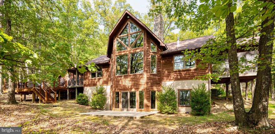 Charming 4BD/3BA Custom Mountain Retreat in Exclusive Gated Community
Nestled on a serene 26.822-acre lot, this custom-built turn-key, fully furnished, mountain retreat offers unparalleled privacy and breathtaking all-season mountain views. The home features a main-level laundry room and pantry for added convenience. The updated kitchen boasts granite countertops, stainless steel appliances, and skylights that bathe the space in natural light. Custom windows frame stunning vistas of the West Virginia mountains. The living area is highlighted by vaulted ceilings, exposed beams, and a grand floor-to-ceiling  fireplace. The main level also includes a full bathroom and a primary bedroom with an ensuite featuring tile floors and double walk-in closets, plus access to one of two screened-in porches. Upstairs, a bright loft with wood floors overlooks the elegant living room and offers magnificent views through large windows. The lower level provides three additional bedrooms, a full bathroom, and a spacious living area with a propane stove, perfect for entertaining. Outside, the property includes a beautifully wooded yard with both flat and sloped areas, attracting local wildlife. Additional features include gutter guards, a whole-house generator, and a low-maintenance paved driveway. All systems in home are new! Don’t miss the chance to own this meticulously maintained mountain retreat. Schedule your appointment today!