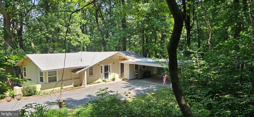 Nestled in the serene Blue Mountain subdivision, this charming raised-ranch/rambler style house was renovated in 2014, including a modern, energy-efficient heat-pump HVAC system, updated kitchen, updated baths, hardwood floors, and more, offering  a perfect blend of comfort and modern living. The main level features hardwood floors, providing an inviting, spacious living area enhanced by a non-functioning, decorative fireplace, French Door walk-out, and built-in bookshelves, adding a touch of warmth and character, making it ideal for relaxation.

Adjoining the living area is a cozy kitchen and dining area, which features granite countertops, updated cabinets, and modern stainless steel appliances, including a refrigerator-freezer, dishwasher, built-in microwave, and electric oven/range, making meal prep a delight, and with ample space for entertaining. 

Two spacious bedrooms and a full bath are situated off the living area, opposite the kitchen-dining area. 

The fully finished lower level provides additional living space with an identical layout to match the main level, featuring an additional two bedrooms, a second full bath, large flex-room perfect for use as a family-room/rec-room/home-office or entertainment area, with a second non-functioning, decorative fireplace, and a grade-level French Door walk-out. 

Step outside to discover the expansive 0.81-acre lot, featuring stunning mountain views, partially wooded back-yard, beautifully bordered by trees, offering a sense of seclusion and tranquility. Outdoor features include a screened-in deck accessible via the living area main level walk-out, perfect for enjoying morning coffee or evening sunsets. There is potential future patio-space located under the deck, accessible via the grade-level French Door walk-out. A gravel driveway and attached carport provide ample parking for residents and guests.  There is an outbuilding for extra storage,  gardening, or other hobbies.  

Blue Mountain POA members enjoy access rights to Deer Lake, within walking distance. This property is a nature lover's dream!