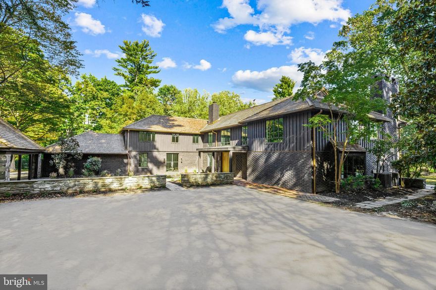Welcome to this masterfully redesigned and completely renovated property, reimagining the former floor plans and opening up stunning sun-filled spaces throughout. The result is a beautiful and timeless amalgamation of the extraordinary original stone walls and structures paired with classic modern enhancements, privately set on a serene 2.5 acre lot on one of the Main Line’s most coveted streets.
Designed by Tallulah & Bird and custom built by Regan Construction Company, it features a dramatic sun-filled two- story entry foyer with massive custom pivot front door and a fully custom walnut and steel staircase, custom Optimum steel windows and doors including a wall to wall folding door from the great room with entertaining bar to the rear patio, dramatic Belgian bluestone tile and French oak wood floors throughout, custom poured concrete counter tops, concrete shelving and concrete fireplace surrounds, fully customized cabinetry, Waterworks fixtures, expansive gourmet kitchen with over-sized walk- in pantry, Blue Star Appliances including a 60” range with two ovens, two side by side refrigerators/freezers and two dishwashers, a wonderful open floor plan leading from the kitchen and dining area to the fabulous family room and rear mudroom areas, 5 bedroom suites including a Primary bedroom with gas-ready fireplace, private terrace and enormous walk-in customizable closet with natural light and a personal washer and dryer, 4 additional secondary bedrooms, each high ceilings, bright steel windows and their own custom tiled en-suite bathroom, one additional second floor terrace and a ready to finish dry lower level. Added design and construction features include the glass enclosed second floor hallway which allows for light exchange while minimizing sound transfer, select custom light fixtures, smart house enabled wiring, restored cedar shake roof, copper gutters & downspouts, stone, brick, and cypress board & batten exterior, 4 zones of HVAC, all powered off of a Lochnivar high efficiency boiler,  radiant floor heat in the primary bathroom, 80 gallon indirect water tank powered by the new boiler, new 320 amp electrical service and more. Enjoy this peaceful oasis while being located just minutes from renowned schools, shopping, restaurants, legendary golf courses and clubs, Philadelphia, 90 minutes from New York City and close to Philadelphia International Airport. Move right in and put your own finishing touches on this piece of artwork.