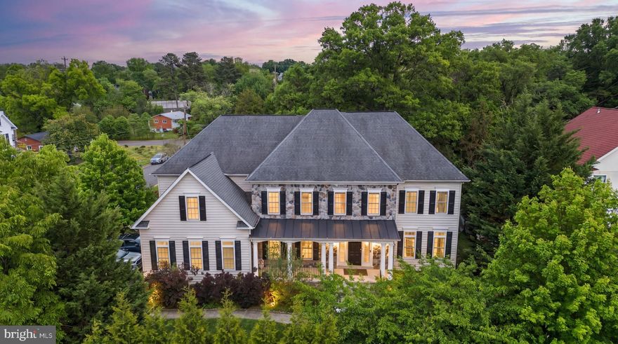 Tucked away on a quiet, tree-lined street in Falls Church, this expansive home offers over 7,500 square feet of thoughtfully designed living space in one of Northern Virginia’s most desirable communities. With seven bedrooms and seven full bathrooms, the home offers the perfect balance of comfort, functionality, and flexibility for modern living.

A classic stone-and-brick exterior welcomes you into a warm, light-filled interior featuring hardwood, tile, and carpet throughout. The spacious layout flows seamlessly from room to room, creating an inviting atmosphere ideal for both everyday living and entertaining. A dedicated main-level office or study provides the perfect space for working from home or a quiet retreat.

The kitchen is well-appointed with high-quality appliances, including double ovens, a refrigerator, and dishwasher, along with ample prep and gathering space. The main living area is anchored by a cozy fireplace, adding warmth and character to the heart of the home.

Upstairs, each bedroom includes its own ensuite bathroom, offering exceptional comfort and privacy for family members and guests alike.

The fully finished basement adds incredible versatility with three additional bedrooms, two full bathrooms, a kitchenette, and a private entrance—ideal for extended family, long-term guests, or an au pair suite.
Major systems have been thoughtfully maintained, including a new gas furnace installed in 2025 for added efficiency and peace of mind. A three-car attached garage and spacious driveway provide abundant parking, with the added convenience of driveway access from the quiet residential street rather than the main road.
Outside, mature trees surround the property, offering exceptional privacy and creating a peaceful setting perfect for relaxing or entertaining outdoors.

Ideally located near Tysons Corner, major commuter routes, and Washington, D.C., the home is zoned for highly sought-after schools including Lemon Road Elementary, Longfellow Middle, and McLean High School. Families will especially appreciate access to the highly regarded GT (Gifted & Talented) program at the elementary level.

Join us for Open Houses this Saturday and Sunday from 11:00 AM – 1:00 PM and experience everything this exceptional Falls Church home has to offer.