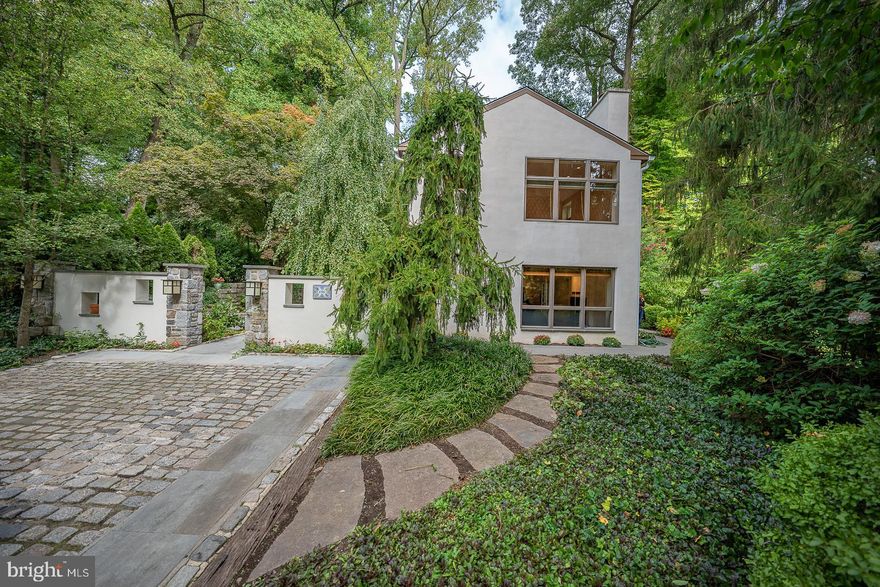 Set atop a gentle hill back from the road you will find this enchanting Northside Bryn Mawr carriage house which was completely renovated in 2015.  Originally a carriage house and separate stable this special property has been combined and renovated to be one living space surrounded by European gardens designed by landscape architect Gordon Eadie, 3 terraces and a grand flagstone courtyard embraced by an 8 foot retaining wall  This courtyard creates a private peaceful area to enjoy morning coffee or host a gathering and is the main entrance to the home.  As you enter the home you will be struck by the sun filled open space where the living and dining areas are both open to the beautiful kitchen with island seating.  Beautiful wide plank cherry floors with radiant heat and a wood burning fireplace with gas starter provide a warmth to this heart of the home.  French doors lead to one of the three terraces where you can soak in the sun and natural setting.  To the rear of the home find a special unique space perfect for an au pair/in law/office or guest quarters which includes a bedroom, full bath, and living area with its own private flagstone terrace.  This charming space is connected to the main carriage home but also has its own entrance.  Cherry flooring continues up the staircase and throughout the second floor where you will find a spacious primary suite with soaring ceilings, a bath with radiant heated floors, dual sinks, walk in shower with multiple heads and a large walk in closet.  A second bedroom suite with full bath and a separate convenient laundry room completes this level.   Enjoy the private setting and scenic views out each window.  This  low maintenance special home is a wonderful alternative to townhome/condo living located in the heart of the Main Line- close to the train, shops, and restaurants.   You must see it to appreciate all it has to offer!