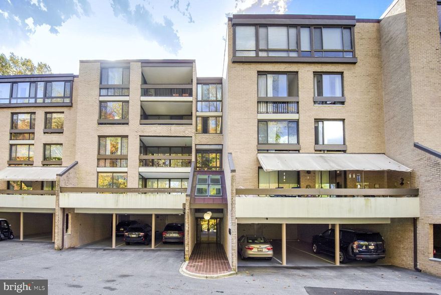 NEW PRICE. Bright and sunny unit on the third floor, with wooded views and a sizable balcony. Close to the pool, exercise center, clubhouse and EV chargers. Shopping, public transportation and the Capital Crescent Trail are all right next door. Dedicated pickleball and tennis courts. Includes two covered tandem parking spaces + extra storage. This lovely unit is one-level (no interior steps) with ample storage (3 walk-in closets!) and lots of updates, including surge protection for the entire apartment. Both the primary and hall baths have been renovated. There is some newer hardwood flooring and the electric fireplace was installed in 2022. Both of the bedrooms are fitted with top down-bottom up shades. The primary bedroom has two closets, including a walk-in. Large living/dining area with floor-to-ceiling windows. Generous kitchen with plenty of cabinets and counter space. Convenient full-size in-unit W/D. Pet friendly!