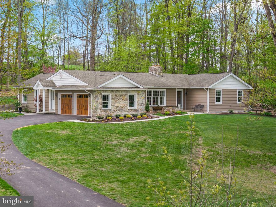 Tucked quietly up a long private drive and set on over 7 acres of wooded grounds in sought-after Hilltown Township, this beautifully renovated rancher offers a rare combination of privacy, thoughtful design, and everyday comfort.

Originally a charming ranch home, the property has been extensively reimagined into a warm, open-concept retreat designed for both entertaining and easy one-floor living. Natural light pours through upgraded Andersen windows, creating a seamless connection to the surrounding landscape and filling the home with a bright, inviting atmosphere.

At the heart of the home is a stunning chef’s kitchen featuring custom cabinetry, quartz countertops, and a large 10-foot island with a pull-out mixer stand and abundant storage. High-end appliances include a 36” gas range with double ovens, pot filler, oversized refrigerator/freezer, microwave drawer, and both a walk-in pantry and additional pull-out pantry storage—making the space as functional as it is beautiful.

The adjacent living spaces are designed for comfort and gathering, highlighted by vaulted ceilings, expansive windows, and a centrally located wood-burning stove that provides both warmth and ambiance.

The primary suite offers peaceful wooded views, a spacious walk-in closet, and a spa-like bath complete with radiant heated floors, a jacuzzi tub, and a glass-enclosed shower. Two additional generously sized bedrooms provide ample closet space, including one with its own walk-in closet, along with a well-appointed second full bath.

The home also features a walk-out basement, offering additional flexible space with direct access to the outdoors—ideal for storage, a workshop, or future finished living space.

Outdoor living is just as impressive, with an expansive EP Henry patio stretching the length of the home—perfect for dining, entertaining, or relaxing by the elevated fire pit while enjoying the natural surroundings. The property itself is mostly wooded, offering privacy, abundant wildlife, and a true sense of retreat.

Additional features include a highly efficient heating system with multiple options, including a heat pump, traditional oil hot water baseboard heat, and both interior and exterior wood-burning systems, as well as a Generac whole-house generator for added peace of mind.

The expansive acreage provides endless possibilities for future expansion, additional structures, or simply enjoying the natural beauty as-is.

Minutes away from local wineries and renowned restaurants, shops, and cultural attractions, with convenient access to SEPTA rail service and major travel routes to Philadelphia, New York City, and beyond, this property offers the perfect balance of seclusion and accessibility.

This is a home that truly must be experienced to be appreciated—a private retreat where comfort, nature, and thoughtful design come together.