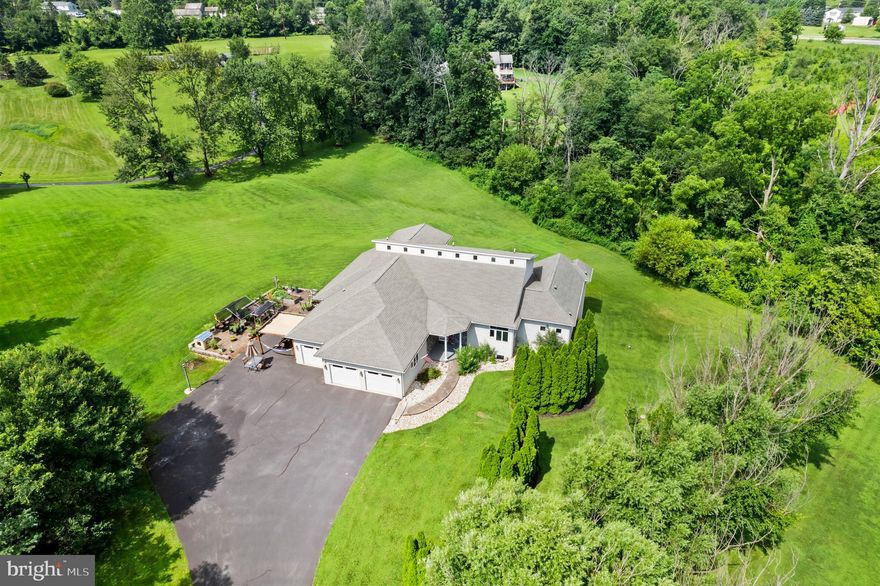 Custom Architectural Masterpiece on 2.37 Private Acres – Versatile Living & Expansive Grounds
This custom 2001 architectural masterpiece by renowned builder Donald Heimbach offers sophisticated modern design on a rare, private 2.37-acre flag-lot estate — perfectly balancing peaceful seclusion with exceptional versatility. Offering 5 bedrooms (and room for more), 3-1/2 bathrooms, and 4,502 sq ft of thoughtfully designed space, it delivers an open, flowing layout that is exceptionally versatile for extended families, multigenerational households, remote workers, and anyone seeking room to live, work, and entertain.
The dramatic main level showcases impressive architectural details and custom craftsmanship with soaring 20-ft vaulted ceilings, abundant natural light, a striking circular steel staircase leading to a large loft with an outdoor balcony, and a wall of windows that opens to an expansive 1,000+ sq ft rear deck overlooking the private yard. Enjoy an open-concept kitchen and living area ideal for entertaining, a main-floor primary suite with deck access and spa-like bath, a dedicated multi-desk work-from-home space, and convenient in-law/guest quarters with private entrance and full bath.
The finished daylight walkout lower level provides exceptional flexibility as a private guest suite, teen suite, or additional versatile living and entertainment area. It includes three large bedrooms, a full bath with a tiled walk-in shower, a kitchenette, and a generous recreation/living space — all bathed in natural light and functioning as a self-contained retreat.
Superior construction shines through with an engineered I-joist floor system, 200-amp electrical service, gas HVAC, and on-demand hot water. Outside, mature trees ensure privacy, while the long macadam driveway offers ample parking for guests or events. Additional highlights include garden areas, room to roam, and abundant wildlife.
This one-of-a-kind property delivers quality craftsmanship, versatile living options, and peaceful acreage living in a highly accessible location just minutes from Routes 100 and 422 in the heart of the Reading-Allentown-Philadelphia triangle. Schedule your private tour today!