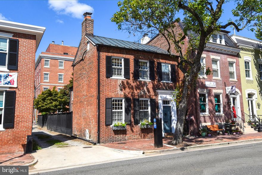 Stunning detached home in the heart of Old Town!  Renovated from top to bottom with no detail overlooked perfectly combining the charm of the 1800's with the function of the 21st century.  Step inside the vestibule and hand carved 200+ year old doors greet you. Beyond those, the parlour boasts original heart of pine floors, 9' ceilings, huge windows, built-in shelving and fireplace with original mantel and new slate surround.  A half bath with designer tile and custom granite sink design, along with coat closet were added where the hallway previously led to the dining room.  Leaving the parlour through the new opening,  you enter the dining room which also has original pine floors, oversize windows, second fireplace and newly installed Federal-style antique chandelier.  From the dining room you will enter the breathtaking chef's envy kitchen.  Huge 4x8 island is a rare find in old town.  Includes seating, additional storage and a beverage/sous chef prep sink.  Built-in beverage center, Jenn Air appliances with commercial grade gas range and industrial exhaust hood, copper hardware and accents, stunning Quartzite (real stone) counters and radiant heat slate flooring are just a few of the upgraded details that make this kitchen spectacular.  New patio doors and windows flood the kitchen with natural light and invite you to the grand patio which makes entertaining a delight.  

Upstairs you will find 3 bedrooms, 2 brand new full baths and laundry relocated to the upper level! The primary bedroom has original heart of pine flooring, 9' ceilings, built-in floor to ceiling closets, and a 3rd fireplace.  En suite bath with designer indigo tile in herringbone pattern, polished nickel hardware, marble flooring, linen closet and 48" vanity with outlet inside--keep the blow dryer and toothbrush charger out of sight.  Second bedroom, also boasting original hardwood floors and the 4th fireplace is currently being used as cozy TV room. The 3rd bedroom is new to include drywall, insulation, ceiling and heart of pine flooring.  Pocket door allows en-suite capability to the sumptuous hall bath. Beautiful, brushed gold hardware,  soaking tub, and heated tile floor make this bathroom a retreat. Hall bath was relocated to service bedrooms 2 & 3 without requiring passage through a bedroom.  

The basement, which is under the original house, is ready for your home gym or man cave. Easily add a wet-bar from the utility sink plumbing/washer-dryer hookups.  

The all-brick patio with raised flower beds provides low maintenance outdoor space with room for gardening.  With multiple entertaining areas it is your choice if you catch a game outside or have a firepit. 
Above all in old town is the coveted parking.  Brick driveway provides 2 off street parking spaces!  With the serenity of the house and patio you won’t even realize King Street and all the action is a mere half block away.   When you want to go out, you have a plethora of restaurants and bars within a few blocks.  Centrally located, the metro and Potomac waterfront are each about eight blocks away. You won't find a better mix of old and new along with the entertainer's dream kitchen, outdoor space and parking! This home truly offers an unmatched blend of historic charm, modern amenities, and convenient city living.

Other items of note: property also zoned for commercial use; new electrical panel; new hot water heater; new insulation in attic;  new pull-down attic stairs and flooring for attic storage; new top of the line storm windows; new light fixtures throughout; fresh paint throughout; upper level doorways extended from the original 6' to 7' height while retaining the 200+ year old trim;