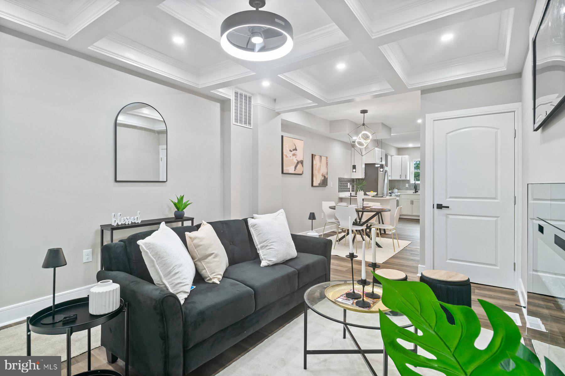 A beautiful transformation has taken place behind the door of this 4BR/3BA townhome located on a tree-lined street in Franklin Square! Open the door and step inside to a stunning main floor offering an open floor plan, custom coffered ceilings, luxury flooring, and recessed and elegant lighting. On the main floor is a spacious living room with a custom electric fireplace feature, a large open dining room, and a stunning kitchen. The kitchen features plenty of cabinets, stainless steel appliances including a slide-in gas range and stainless and glass vent hood, sleek quartz countertops, a gorgeous tiled backsplash, a stainless sink under a window, a peninsula with pendant lighting and breakfast seating for two. Onto the newly carpeted second floor featuring two large secondary bedrooms each with a private bath, one with a deep soaking tub, the other with a beautifully tiled walk-in shower. In addition, for your convenience is laundry. On the third floor is the primary owners suite boasting a large sunny bedroom, and a private full bath with a beautifully tiled walk-in shower. From the kitchen step outside to a newly fenced yard filled with tons of possibilities. This home is move-in ready with so much to offer new homeowners, and is conveniently located in close proximity to shopping, restaurants, and commuter routes.