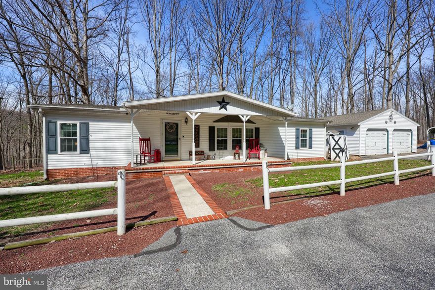 Don’t miss this incredible opportunity! Situated on 1.32 private acres, this property features a two-car detached garage with additional side parking for an RV, plus a second detached garage equipped with heating, electric, cooling, and a kitchenette—ideal for hobbies, a workshop, or extra flex space. Enjoy peaceful wooded views from the rear deck and screened-in porch, complete with a built-in bar for effortless outdoor entertaining. Inside, you’ll find a bright, open layout highlighted by a cozy fireplace in the living room. The spacious primary suite offers a double-door entry, walk-in closet, and an en-suite bath with a double vanity. The kitchen features upgraded countertops and cabinetry, along with a dining area that provides direct access to the screened-in porch. Two additional bedrooms and a full guest bath are thoughtfully located on the opposite side of the home. A perfect blend of privacy, functionality, and outdoor living—ideal for hobbyists or anyone seeking a serene retreat.