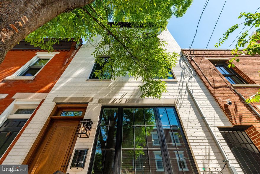 Welcome to 2211 Naudain Street, an exquisite home located on a tree-lined block in the highly sought-after Fitler Square neighborhood. This stunning residence, situated on a generous 17-foot-wide lot, boasts 4 spacious bedrooms and 3.5 luxurious baths. From the moment you arrive, the home's distinctive black Pella windows and mahogany Pella front door captivate your attention.

As you step inside, you'll be greeted by a bright and inviting living room featuring gleaming 7-inch wide hardwood flooring and soaring 9-foot ceilings. The open floor plan seamlessly connects the living area to a wide dining space and a chef's dream kitchen. The kitchen is equipped with Wilsonart quartz countertops, a large island with seating for four, top-of-the-line Thermador appliances, Restoration Hardware lighting, and sleek matte black fixtures. A true showstopper is the four-panel glass multi-slide pocket door that opens completely to reveal a back patio, perfect for entertaining. The patio is adorned with a custom metal awning, enhancing your outdoor living experience.

Back inside, a beautifully crafted stairwell with a custom railing leads you to the second level, where you'll find two oversized bedrooms, a laundry room, and a magnificently tiled bathroom featuring Kohler finishes. The third floor is dedicated to the primary suite, a sanctuary of elegance with basket weave marble flooring, marble walls, Kohler fixtures, a stylish wooden vanity with double sinks, a large free-standing soaking tub with Center City views, and a massive shower stall with custom doors. The suite's walk-in closet is generously sized and fully outfitted with drawers and shelving. Just outside the primary bedroom, there is a convenient half-bath, perfect for guests.

The fourth floor offers access to a massive roof deck with breathtaking skyline views, ideal for entertaining friends and family. The fully finished basement, with 8-foot ceilings and a full bathroom, can serve as an additional living area or a LEGAL fourth bedroom. The basement's sliding glass door allows for natural light and egress. Additional features include a French drain, sump pump, and extra storage space.

This home has over seven years left on the TAX ABATEMENT, is located in the Greenfield School Catchment, and offers dual-zone heating and air conditioning. Just steps away from the Schuylkill River Trail, dog park, coffee shops, restaurants, supermarkets, Rittenhouse Square, CHOP, Penn, and numerous other Philadelphia attractions, this home is a walker’s paradise.

Seller is offering a 1 year pre-paid parking credit with an acceptable offer.  ** some photos have been virtually staged.