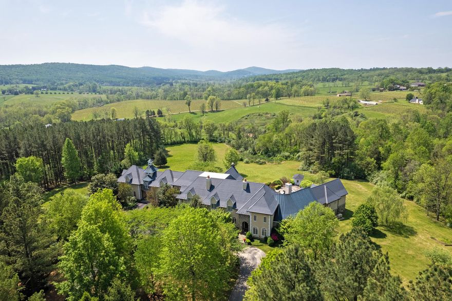 Perched majestically in Virginia's prestigious Hunt Country, "The Looking Glass" estate offers an unparalleled living experience across 30 breathtaking acres. Named for its sweeping panoramic views of the mountains and neighboring vineyard, this Tuscan-inspired masterpiece seamlessly blends old-world charm with modern luxury.

The magnificent main residence spans 17,000 square feet, with 11,000 square feet of meticulously designed living space on the first two levels and an additional 6,000 square feet on the lower level with room for further customization. Featuring five sumptuous bedrooms and ten elegant bathrooms, the estate creates an atmosphere of refined opulence through its exceptional construction and meticulous maintenance.

The exterior showcases a harmonious blend of stone and stucco, complemented by distinctive arched doorways and windows that define its architectural character. Inside, rich hardwood, natural stone, and luxurious marble flooring extend throughout, while wrought iron staircases add to the estate's old-world ambiance.

Outdoor entertaining reaches new heights with a heated pool and spa adjacent to an inviting pavilion featuring a stone terrace and outdoor fireplace—all overlooking the estate's stunning grounds and breathtaking vistas.

The property is further enhanced by a spacious 2,500-square-foot guest house offering four bedrooms, generous living spaces, and a full kitchen. Equestrian enthusiasts will appreciate the connecting eight-stall stable with its grand ceiling, convenient wash stall, and well-appointed tack room.

"The Looking Glass" represents an extraordinary opportunity to own one of Hunt Country's most distinguished estates.