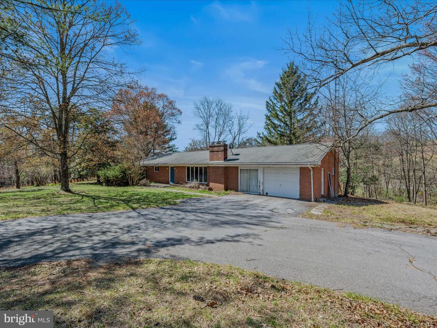 Location is everything!  Amazing potential in this sturdy 1970 brick home just minutes from downtown on 2 lots totaling 2.73 acres that backs to the Lakewood Hills common area for added privacy and outdoor enjoyment!   Paved streets and circular driveway with 1 car garage and added work shop space or office.  House is comprised of 3 bedrooms, 1.5 baths, kitchen/dining, and living room with wood burning fireplace on a full basement with additional fireplace.  The home needs work but could be a real gem! You could be the visionary to restore it to it's former glory days! Partially fenced yard and shed. Old RV on the property stays and will not be removed. Home has not been lived in since a renter last year so the water and sewer are off and will not be turned on for any inspections.  THIS PROPERTY IS STRICTLY BEING SOLD AS-IS.