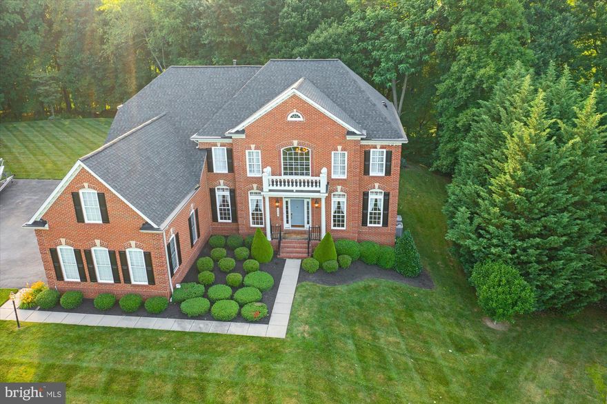 Welcome to 102 Bower Ln, a gorgeous brick colonial situated on 1.7 private acres offering over 8,000 sq. ft. of finished living space with a 3-car garage and in-law suite in the lower level. The rear yard features extensive professional hardscaping, serene wooded views with beautiful landscaping, a maintenance-free composite deck, and a built-in hot tub. Upon entry, you are greeted with a grand 2-story foyer, which highlights the open concept floor plan, detailed wood trim, and recently installed hardwood floors throughout the main level. The gourmet kitchen features a large island, ample granite countertop space, backsplash, and a walk-in pantry. The main level offers a 2-story family room with custom built-in shelving, formal executive office, living room, dining room, half bathroom, and laundry room. The upper level consists of 4 spacious bedrooms, each with its own private full bathroom. The primary bedroom features a tray ceiling, ensuite bathroom with dual vanities, jacuzzi tub, vaulted ceiling, and a massive walk-in closet. The walk-out lower level includes a theatre, fitness room, bedroom/office, recreation room with a custom wet bar and beverage fridge, updated flooring, and an in-law suite with its own rear entrance. Impeccable details were thought out in every aspect of this home. You do not want to miss out on this opportunity! Major updates include: Roof (2019), Water Heater (2021), Hardwood Flooring and Staircase (2019), New Carpet in Primary Bedroom (2019), New Water Treatment Tank (2020), Deck and Hardscaping (2018), Front Door (2019), Screen Door off Kitchen (2019), Hot Tub Pump (2021), Waterproof Flooring in Basement and in-law Suite (2018).