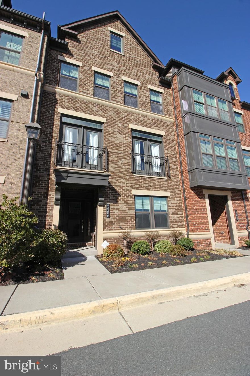 Welcome to a spacious and stunning 5 bedroom, 4.5 bathroom townhouse, conveniently located within walking distance of the Ashburn Metro Station, offering a perfect blend of comfortable living and easy access to public transportation. The house has 4 levels and a light-filled open floor plan, more spacious than you thought possible in a Townhome. This amazing space offers 3,750 square feet of luxurious living space. Boasting 5 spacious bedrooms, 4.5 baths, a 2-car garage, a private balcony, and a rooftop terrace. You will find the first floor with upgraded tiles and an area for coats and accessories. The first bedroom on this level has LVP flooring, a walk-in closet, and a full bathroom with granite countertops. Heading up the oak staircase with elegant metal balusters to the expansive main level. The second level has an enormous kitchen island in the center of the open-concept kitchen, featuring an upgraded refrigerator, cooktop, hood vent, and faucet. LVP flooring with a spacious living area and dining area. Slide open the balcony doors to an expansive balcony. LVP flooring throughout on the third floor. The luxurious primary bedroom includes 3 closets with French doors, custom shelving in hers closet, and an ensuite bathroom with granite countertops, dual vanities, and upgraded tile in both the floors and shower. Granite countertops in the hall bath. The laundry room is fully upgraded with high-end washer/dryer and floor tiles. You will find custom wainscoting and personalized shelving in the second and third bedrooms. The top floor has a loft area that can be used as a second living space or entertainment/movie room, along with a private bedroom, each with LVP flooring. The full bath has upgraded granite countertops. You can find the additional features such as upgraded blinds, custom light fixtures, and modern touches throughout this Townhouse. The Westmoore community provides excellent amenities including two expansive parks, a dog park, an amphitheater, playgrounds, a clubhouse with a pool and fitness center, and miles of scenic trails. This Townhouse is close to the Ashburn Metro and has easy access to shops, restaurants, the Dulles Greenway, One Loudoun, and Dulles International Airport.  Available Now!