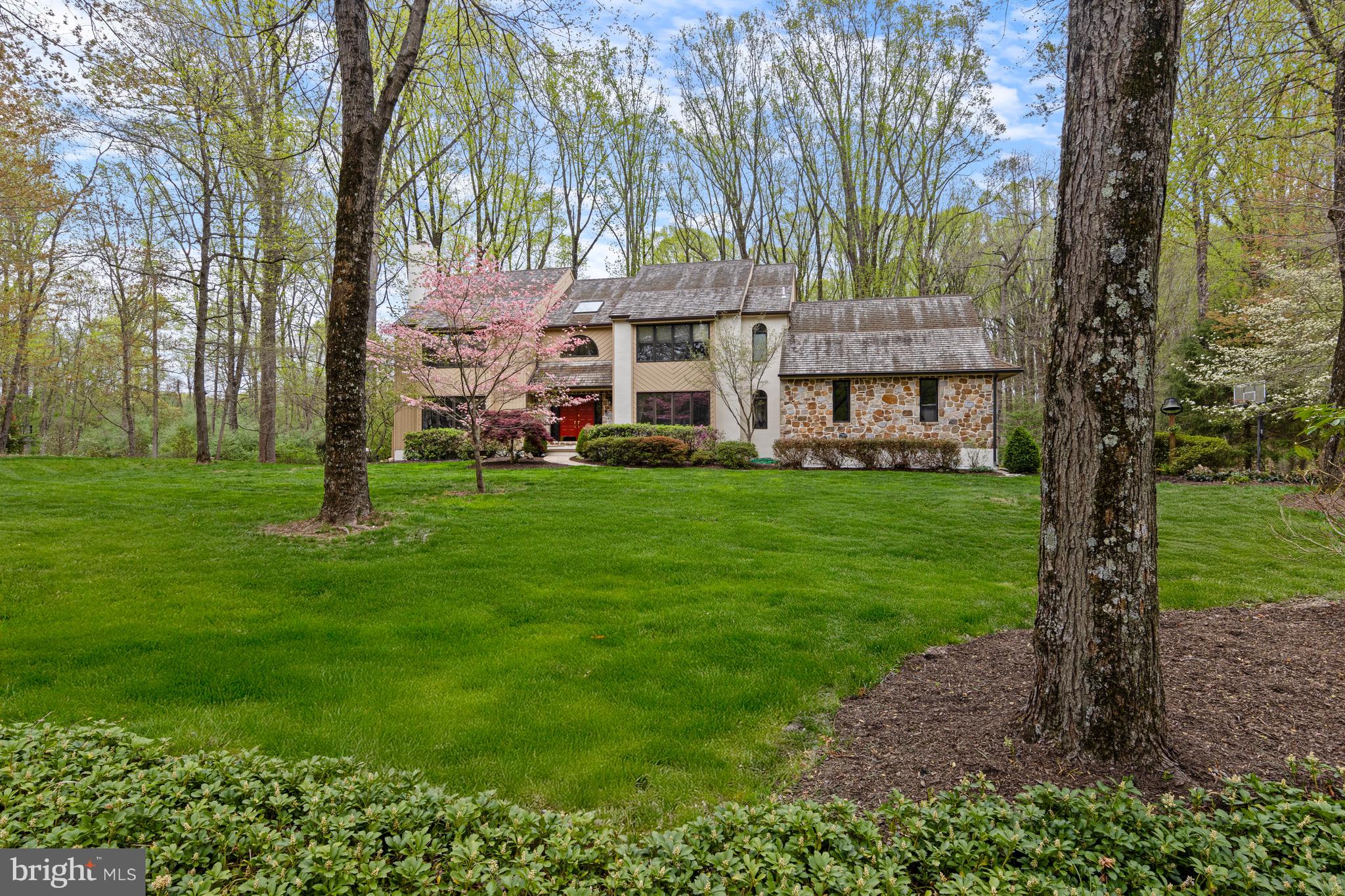 This home has all of the charm and privacy of a mountain retreat yet enjoys close proximity to shopping and local businesses as well as Unionville-Chadds Ford schools. Set in the quiet and desirable neighborhood of Waterford, this 1-acre property affords long setbacks and wide spaces between houses. The mature trees line this quiet street. Enter this 4BR, 3.1 bath home and immediately notice the wood floors that run throughout much of the main level as well as the large 2-story foyer with turned staircase. To the left is a large living room with fireplace and window seat. Continue through pocket doors to the office with built-in shelving. Another set of pocket doors leads to the massive 2-story family room with stone fireplace, picture windows and access to the sprawling Trex deck. The rear of the house overlooks lush, wooded space creating the perfect atmosphere for rest and relaxation. Continue on to the large eat-in kitchen with quartz counters, breakfast area and island with seating. A formal dining room is located off of the kitchen and foyer. A convenient laundry room, powder room and access to the large screened-in porch and 2-car garage complete the main level. Head upstairs to find the primary suite with large bedroom and updated en-suite. Three additional well-sized bedrooms share an updated guest bath. The finished lower level walk-out is perfect for relaxing and entertaining. A media room with large windows allows for loads of natural light and leads into a billiards room with built-in bar. An additional room with fireplace and patio access would create a perfect in-home office. This scenic oasis has been lovingly maintained and is ready for its new owners!