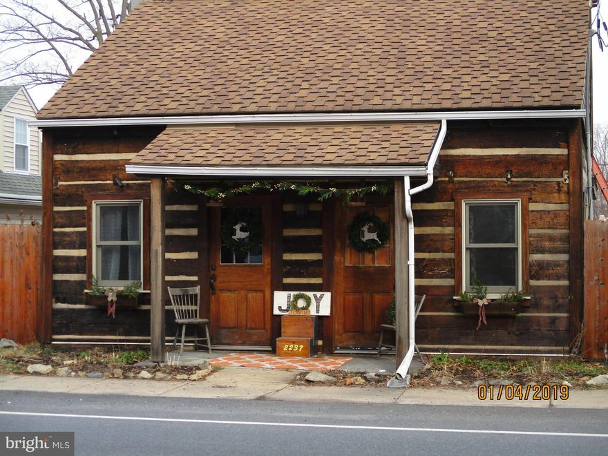 Unique pre 1875 log home lovingly restored & updated thru out. From the custom made Spanish cedar wood Indian doors,  beamed LR ceiling, corrugated convection wall behind the woodstove, the handmade pallet light in the kitchen, corrugated kitchen ceiling, new master bath & laundry on the 1st floor, to the 3 -  4 BR's on the upper level, you will find old world charm and today's amenities complete this sweet home. There is new carpet in all the BR's, new laminate in the master bath w/ hookup for a stackable washer/dryer,  updated windows, freshly painted siding & 200 AMP service. Kitchen offers a breakfast bar, lots of cabinets, nice countertop workspace and a refrigerator nook by the French doors to the deck. You'll love relaxing on the side porch in the summer & enjoy the large side/rear yard for outdoor family fun.  The 2 small BR's on the 2nd floor with loft beds can be converted back into 1 large room. The 2 other rooms offer 1 large bedroom with exposed lo,gs & vaulted ceiling. The large walk thru room could be a den/playroom/family room or homeschool space but won't be considered a BR for financing. The basement currently houses the laundry(new laundry on the 1st floor) & has ample storage w/steps leading to the rear yard &  along with the gas furnace & gas water heater. Don't miss seeing the candle nook in the stone foundation! The level yard is partially fenced and has a large stoned area for off street parking for at least 3 - 4 cars. The 2 car garage does need some work, and is being sold in as is condition,  but it has nice workshop space .  Lovely mix of old world charm & HGT highlights.