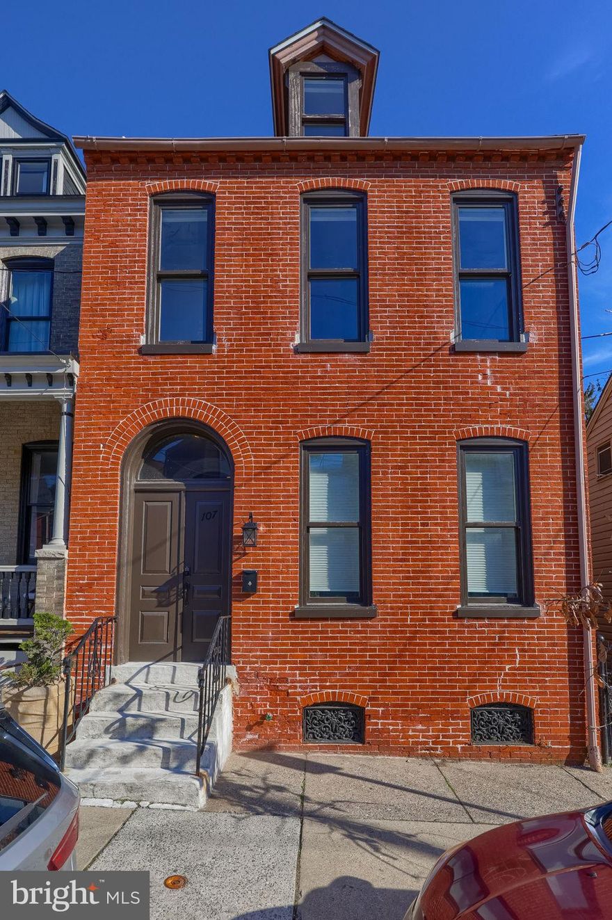 Welcome to 107 Church St. This inviting historic row home blends timeless charm with modern convenience, just a short stroll from downtown restaurants, shops, and attractions. Enjoy the natural light and sense of space that comes with an end unit, along with high ceilings, beautiful hardwood floors, and a beautiful staircase that serves as the home's focal point. The spacious living room flows into an updated kitchen with granite countertops, stainless steel appliances, and access to a private patio, making it perfect for entertaining or relaxing. This move-in ready home offers 4 versatile bedrooms and 1.5 baths, including a recently refreshed full bath with stylish tile and glass enclosure. The third floor provides flexible space for a home office, media room, or guest retreat. Outside, enjoy a generously sized yard with a hot tub as your own private oasis. Ductless mini-split systems on each level ensure comfort all year long. A perfect blend of location, character, and modern updates. Schedule your showing today!