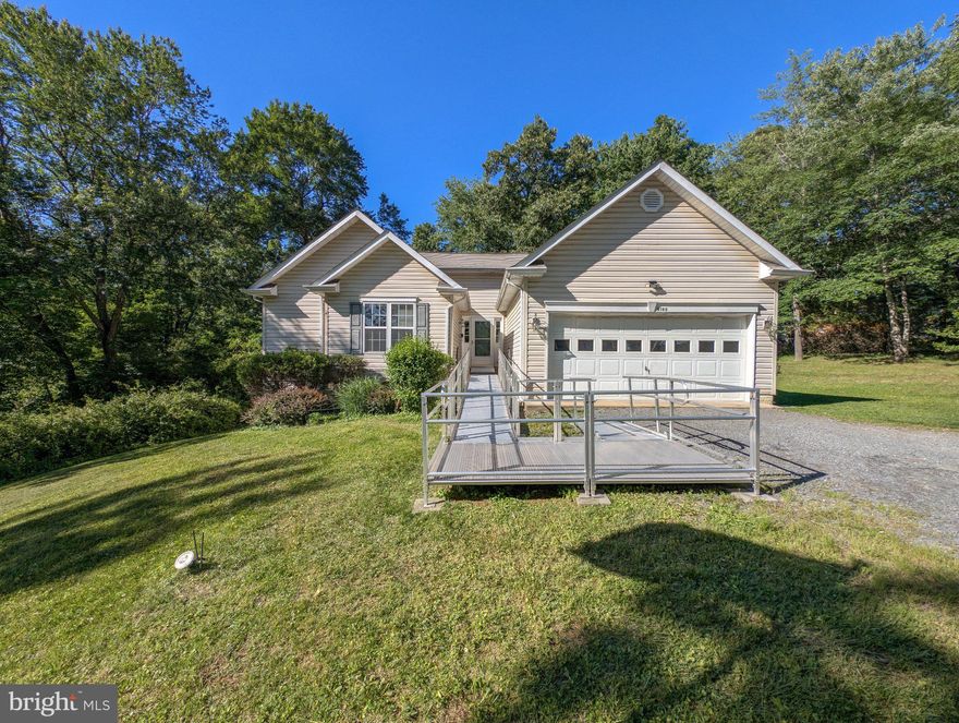 This 2005-built rambler offers a rare combination of total privacy and functional single-level living on a sprawling 2.1-acre lot. Tucked away on a quiet, low-traveled road and buffered by a thick line of mature trees, the property provides a sense of seclusion while maintaining the essential connection of high-speed internet. The home was designed for full accessibility, featuring a front entry ramp, main-floor laundry, and a chair lift to the basement, ensuring everything you need is within easy reach. While the interior anchored by a cozy gas fireplace is ready for your personal touch, the exterior includes a rear deck overlooking a large backyard. Sold as-is.