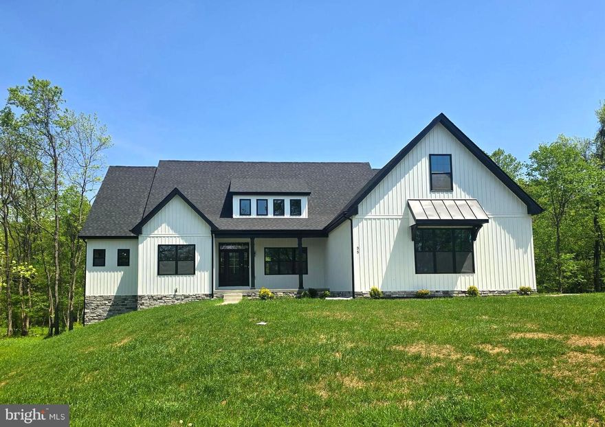 Move-in Ready TODAY! – New Price Just Announced! This stunning new construction home is nestled on a beautifully wooded 2.19± acre lot in an established, highly sought-after neighborhood. Thoughtfully designed to blend seamlessly with the surroundings, this modern farmhouse-style ranch offers 4 spacious bedrooms, 4.5 luxurious baths, and a versatile bonus room over the garage—perfect for a home office, guest suite, or additional bedroom with its own full bath.
Crafted with quality in mind, the home features an upgraded kitchen with quartz countertops, a premium appliance package, soft-close cabinetry, and luxury vinyl plank flooring throughout. Soaring vaulted ceilings add to the open, airy feel, while the full unfinished basement offers endless potential. The beautifully appointed primary bedroom suite includes a spa-like bath and generous closet space—your own private retreat. 
Out back, a peaceful wooded setting offers privacy and frequent visits from local deer—a true touch of nature right outside your door.
Enjoy a secluded country feel while being just minutes from downtown Martinsburg and close to everything the Eastern Panhandle has to offer. You’ll soon discover locals’ favorite farm markets, coffee shops, and bakeries nearby. Plus, you're a short drive to Harpers Ferry, Shepherdstown, and Charles Town—perfect for exploring, dining, and weekend adventures.
Now offered at a new price—this beautifully crafted home is available and waiting for you! 
Photos are of the actual home.