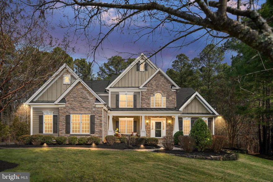 Welcome to this stunning Toll Brothers Waterford II luxury residence, showcasing exceptional craftsmanship and elegant design, located in the prestigious gated community of Fawn Lake.  Offering approximately 6,260 square feet of finished living space across three levels, this home features 6 bedrooms and 6 bathrooms and was thoughtfully designed for both everyday living and memorable gatherings.

From the moment you walk in, the two-story foyer makes a striking first impression with its elegant curved staircase and open balcony overlooking the main living space. Just beyond, the impressive two-story great room is filled with natural light from oversized windows and centered around a stunning floor-to-ceiling stone gas fireplace, creating a warm and inviting place to gather.

The main level offers a natural flow that makes entertaining feel effortless. A formal living room and dining room lead into the dramatic great room, while the chef’s kitchen sits at the heart of the home. The kitchen features a large bar-style island with modern black quartz countertops, perfect for casual meals or gathering with friends while cooking. The adjacent breakfast area, surrounded by floor-to-ceiling windows, fills the space with natural light and can easily serve as a second dining area or relaxed sitting space. From here, doors open directly to the backyard deck, creating a seamless connection between indoor and outdoor living.

The main-level primary suite offers a peaceful retreat with soaring vaulted ceilings that make the room feel open and airy. The suite includes a spa-inspired bathroom and a large walk-in closet with custom built-ins, offering both comfort and thoughtful organization.

Upstairs, you’ll find four spacious bedrooms and three full bathrooms, along with flexible space that works perfectly as a lounge, study area, or playroom.

The fully finished lower level adds even more living space with a large recreation area, a dedicated home gym with surround sound, and a private guest suite with a bedroom and a full bathroom. With its own access to the outside, the lower level works beautifully for visiting guests or extended family.

The home includes many thoughtful upgrades, including Cat6 network wiring throughout the house and a pre-wired speaker system that allows music to play throughout the interior and outdoor spaces. Several closets feature professionally installed built-ins by Closets by Design, and the mudroom includes the added convenience of a second stackable washer and dryer.

Outdoor living is just as special. The backyard features a Trex deck and flagstone patio built by Fredericksburg Deck Builders, along with an outdoor barn-door style television and a private hot tub, creating the perfect space to relax or host gatherings. The yard offers exceptional privacy thanks to the natural wooded buffer behind the home. A professionally installed irrigation system and beautifully maintained landscaping keep the property looking its best year-round.

Life in Fawn Lake offers a lifestyle that truly feels like a resort. The private lake spans over seven miles of shoreline, offering endless opportunities for boating, paddle boarding, kayaking, swimming, and fishing. Residents enjoy convenient water access to the country club restaurant, pool, and deep-water docks. Golf enthusiasts will appreciate the Arnold Palmer–designed 18-hole golf course, while the family-friendly community also features tennis courts, basketball courts, volleyball courts, pickleball courts, soccer fields, baseball fields, and a swimming pool. The marina offers boat slips for rent, and additional amenities include walking trails, a clubhouse, fitness center, Lakeside Restaurant, Country Club, and playgrounds. In Fawn Lake, nearly every amenity you can imagine is just outside your front door.

This home offers not only beautiful spaces, but a lifestyle centered around comfort, privacy, craftsmanship, and enjoying time with family and friends