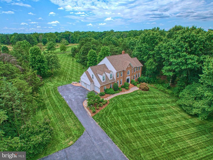 This executive home is situated on just over 5 acres of lush, manicured grounds, boasting a grand entrance with a long winding drive and backing to a prestigious golf course. The stately and dignified curbside presentation, with its 3-car side-loading attached garage, sets the tone for the opulence that awaits within. 

Inside this 5-bed, 3.5-bath you will find nothing but the finest appointments and thoughtful designs from hardwood floors and gorgeous crown moldings to curved transom windows, plantation shutters, and recessed lighting. The oversized sunroom is a haven of tranquility with its Brazilian hardwood floors, ceiling fan, and walls of windows offering stunning views of the wooded property and golf course. 

Just off the kitchen is a welcoming family room, featuring a gas fireplace with a brick surround and a delightful bay window with a seat, as well as French doors leading to the oversized back Trex deck.

The gourmet kitchen is a chef's dream, with its expansive views, bay window breakfast area, built-in bar with wine fridge, and gleaming granite countertops.  The island with a gas cooktop, wall oven, built-in microwave, large pantry, and custom crown moldings add to this kitchen's allure. 

Conveniently connected to the kitchen is the mud/laundry room, providing practicality without sacrificing style. 

Upstairs, the primary suite is a sanctuary of luxury and relaxation with vaulted ceilings and a custom accent wall adding to the allure of the room, which overlooks the golf course. A separate sitting room with built-in bookshelves and a generous walk-in closet with a custom closet system is sure to impress along with the lavish 
en-suite bath, featuring tile flooring, a double sink vanity, a frameless shower with multiple shower heads and steam, and a separate jetted tub – the epitome of indulgence. 

Three additional bedrooms, one with a vaulted ceiling and two closets, provide ample space for family or guests. 

The walk-out lower level is designed for entertainment and recreation, with tile flooring mimicking wood, a large rec room with built-in bookcases, recessed lighting, and surround sound. This level also includes a full bath, a gym, and a 5th bedroom with Berber carpet, recessed lighting, and beadboard details. 

Nestled in the highly sought-after community of Sully Estates, this home's peaceful oasis offers the perfect setting for gatherings with friends and family. The neighborhood's HOA includes access to a community pool, while nearby parks, walking trails, and optional golf memberships cater to an active lifestyle. Enjoy the serenity of your retreat while being conveniently located to shopping, entertainment, and major commuter routes. Don't miss the opportunity to experience the pinnacle of luxury living in this exceptional executive home.
