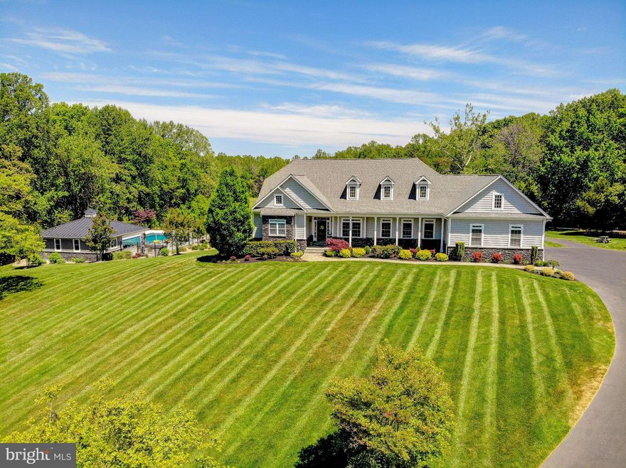 Experience the perfect blend of luxury, privacy, and functionality with this exceptional custom-built Craftsman-style rambler, situated on over 16 acres of beautifully maintained and partially wooded land. Built in 2016, this 7-bedroom, 5 full and 2 half bath estate offers refined living with high-end finishes and thoughtfully designed spaces throughout.

The main level features 10-foot ceilings, rich hardwood flooring, and an open, inviting layout centered around a spacious family room with a gas fireplace. The gourmet kitchen is appointed with custom cabinetry, marble countertops, and premium finishes, ideal for both everyday living and entertaining. The expansive primary suite offers a private retreat with a walk-in closet and spa-inspired bath, complete with a jetted tub and walk-in shower.

The fully finished walkout lower level, with 9-foot ceilings, provides additional living and recreation space, including a dedicated home theater and whole-home audio system. Every room is designed for comfort and entertainment, enhanced by a Control4 smart home system that seamlessly integrates lighting, security, audio, and more.

Step outside to your private resort-style setting featuring a 25x40 heated gunite pool with PebbleTec finish, automatic cover, and extensive hardscaping. The custom pool house is an entertainer’s dream, complete with a full kitchen, wet bar, gas cooktop and oven, dishwasher, refrigerator, and a full bath with laundry. Thoughtful custom woodwork carries throughout the interior and exterior, creating a cohesive, high-end design.

Designed for year-round enjoyment, the pool house is fully heated and cooled and enhanced by integrated surround sound throughout both the pool house and pool area. Both the main residence and pool house feature newly installed permanent Govee lighting, ideal for everyday use or seasonal displays.

The property is further supported by a comprehensive security system, including exterior cameras covering much of the grounds and a full alarm system for added peace of mind.

Additional improvements include a 3-car oversized garage with custom flooring, heating and cooling, a 50x100 pole barn with full concrete flooring, and a custom wood barn equipped with electric, projector, surround sound, and lighting—perfect for multi-use or entertainment space.

The property is further enhanced by a slate front porch and walkway, custom landscaping, black aluminum fencing, and a full-yard irrigation system covering approximately 3 acres. A charming custom-built playhouse mirrors the main home’s architecture, adding to the property’s unique appeal.

Modern infrastructure includes insulated vinyl siding, a whole-home water filtration system, dual tankless water heaters, upgraded well pump (1.5 HP), and a 48kW whole-home generator, ensuring comfort, efficiency, and peace of mind.

This one-of-a-kind estate offers a rare opportunity to own a private, amenity-rich retreat in a highly desirable Southern Maryland location.