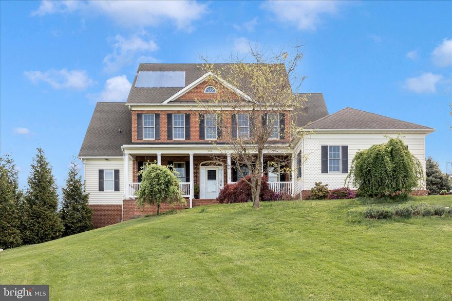 NEW ROOF TO BE SOON INSTALLED
With over 5,700 square feet, this stately brick-fronted Executive-style 6-bedroom, 4.5 bath Colonial sits on a small knoll and features 360 degree views. Inside, the expansive interiors lend themselves to gracious living. Outside, you will fall in love with the bucolic, pastoral views while enjoying your beautifully landscaped piece of paradise.  Set back off the road, this petite pocket neighborhood (NO HOA) of elegant homes on large lots is surrounded by hundreds of acres of farmland. Perfect for a family that entertains or a multi-generational family, this home features, inside and out, multiple spaces to gather, multiple places for privacy, with plenty of flexible space that can be adapted to suit any set of needs at any given time. 

The interior of the home tastefully combines classical design elements with contemporary touches and blends the best of traditional dedicated rooms with open-space concept areas. 9’ ceilings, crown molding and hardwood floors throughout, plus upgraded contemporary lighting with traditional ceiling medallions. 

Foyer opens on one side to a library/study/home office, and on the other side to a formal dining room; a gracious contemporary living room with traditional touches, such as the colonial detailing on the fireplace mantel and French doors opening to more outdoor living spaces. 

Open concept Kitchen/Breakfast Room/Sunroom captures abundant east and south natural light. Nicely sized island, granite counters, stainless steel appliances, plus cherry cabinets with BOTH undermount and overmount lighting!  Main level mudroom to the 2-car garage – yes, with the indoor charging station. 

Massive main-level primary suite gets morning light from oversized windows and opens to a deck. Ensuite has jetted soaking tub, separate shower, separate sink vanities and a makeup vanity – and of course an ample-sized walk-in closet. 

Upstairs is a junior suite (bedroom with walk-in closet and a private bathroom), two bedrooms (with walk-ins) joined by Jack-and-Jill bath, and then a large, finished room with smaller interior room that is open to interpretation. Bedroom? Family Room? Home office? Home schooling? Convert to a second master suite? 

Meanwhile, 1,400 sf of lower level was upgraded and updated in 2019. The comfortable lounge/gathering room centers on sleek, contemporary, eco-friendly flush mount electric fireplace, with plenty of room for pool table and more. The high-design expansive bar could have been plucked out of an on-trend boutique hotel! All the right things are present:  wine fridge, second drink fridge, sink, dishwasher and a combination microwave/convection oven. A nook is ready for a kegerator or full-size fridge.  Plus, a full-size bedroom and an upscale European spa-style full bath. French doors open to yet another at-grade outdoor entertaining area. Entire lower level could easily be set-up for au pair or in-laws 

Extensive landscaping and gardens (flower gardens, lavender herb gardens, vegetable gardens – great for homesteaders, and passionate cooks) and flowering ornamental trees – and a garden shed of course!

Additional outdoor living spaces include:
• Spacious brick front porch promises magical sunsets.   
• Lunch under the wisteria draped pergola
• Cocktails while grilling
• Built-in fire pit for star gazing. 
• Another gathering area, which could be a spot for a hot tub or more. 

Home is updated with smart recessed lighting throughout, able to be remote controlled for brightness and type of light (daylight, reading, etc.). Smart thermostats. Fiber optic has been laid and has been promised to be available soon! Meanwhile, sellers have used Starlink and rave about its service and reliability. Reasonable commute times to Frederick, Baltimore, Fort Meade, Fort Detrick, the 270-Biotech Corridor, Columbia, Ellicott City and Westminster.