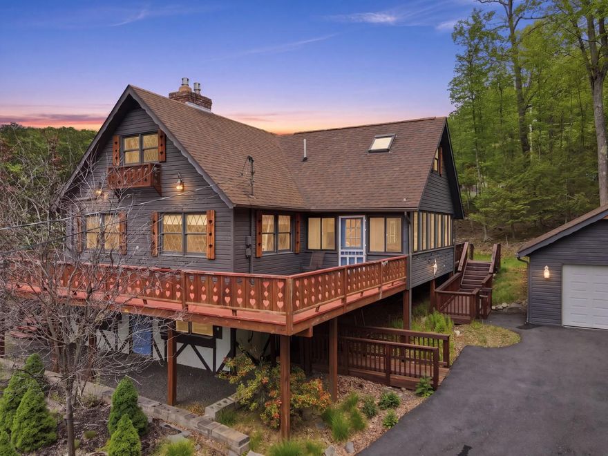 A massive floor-to-ceiling brick fireplace, rumored to contain at least 3,000 bricks, anchors this Swiss-style chalet as it runs through the center of the home to warm both the main living area & finished family room below. Modern propane inserts give you all the ambiance of a traditional fire without the hassle of wood. Built in 1980 in Tanglwood Lakes, this 4-bedroom, 3-bath mountain lake house features warm wood floors and a wall of windows that provide the main living and dining area with natural light. The galley kitchen has granite countertops and a lot of workspace! The main-floor primary bedroom is a relaxing space w/ its own private balcony. Also on the main floor: full bath, laundry hookup, & bedroom that opens directly onto a beautiful screened porch overlooking the backyard. (This versatilebedroom could easily transition into a home office or den depending on your needs).A heated sunroom extends off the living room and can be used year-round. The upper level offers 2 more bedrooms, full bath, a spacious open loft, and a nearly finished bonus room. Downstairs, the finished lower level holds a family room featuring the remainder of that impressive fireplace, a full bath with a soaking tub and separate shower, a laundry area, and a flexible workshop or storage room. Practical aspects include an attached golf cart garage, a detached two-car garage, & a paved driveway. Move outdoors onto the extensive deck, perfect for outdoor entertaining. Enjoy excellent community amenities, including a beach, picnic area, and boat launch on Lake Wallenpaupack, plus fishing and paddling on Lake Tanglwood (no gas motors on Lake Tanglwood) just ⅓ mile away, as well as Paupack Hills golf course. There's a clubhouse & fitness center, too. Beyond Tanglwood Lakes, you are within a short drive of hiking & fishing at Promised Land State Park, skiing at Ski Big Bear, Camelback, Jack Frost/Big Boulder, or Elk Mountain. Go shopping & out to eat nearby, too. Info is deemed accurate but should be independently verified.