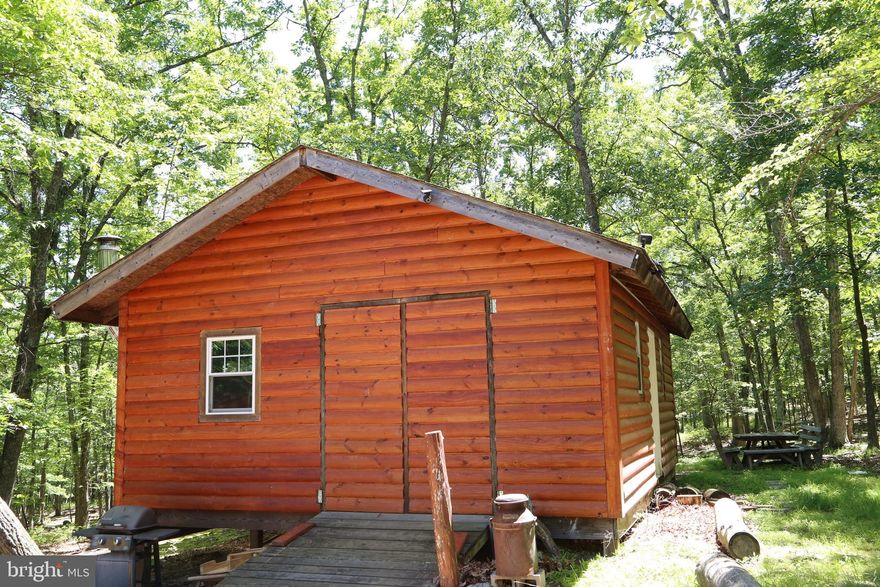 Discover serenity at this enchanting property nestled within Lost River Ridge Subdivision. A captivating, mostly wooded lot bustling with wildlife. The previous owner has started the transformation of this haven into a weekend retreat or a tranquil full-time sanctuary. At the end of a gravel driveway, two charming log-sided buildings await. The larger 20'x30' structure would serve as the main living area, featuring a cozy wood stove. Accompanying this is a smaller building, perfect for hosting guests. Just a brief 10-minute drive away lies the charming town of Wardensville, boasting a  bookstore, coffee shops, eateries, and vibrant farmer's markets. Escape the hustle and bustle with a mere 2-hour drive to DC, making this idyllic retreat both accessible and secluded. Don't miss the opportunity to witness the beauty and potential of this property – schedule your showing today!