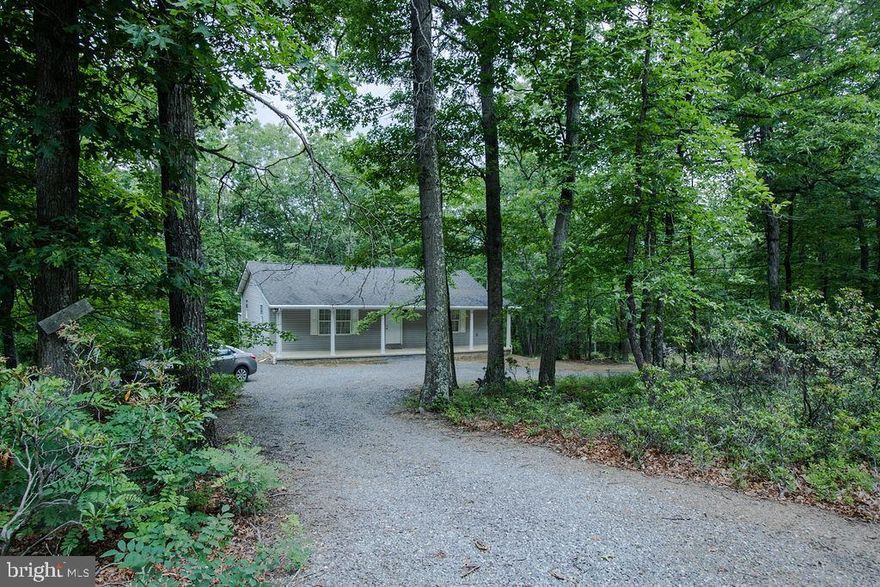 UPDATE: With a FULL PRICE OFFER, the  2010 John Deere  3005 Tractor, with approximately 150 hours, with bucket and bush hog, and primary home furnishings convey. Move in ready home.
There is a unicorn in Capon Bridge, West Virginia and it is a “must see” for anyone looking for a “glambin” (that’s a glamorous cabin) and the peaceful easy feeling of being surrounded by over 100 acres of valuable timber, beautiful pastures, and views that could require CPR to regain your breath!  The outside of the home is easily maintained siding and there is a concrete front porch to sit and watch nature and the surroundings. This move-in ready rancher has two main level bedrooms (one bedroom is currently utilized as a den), full bath, living room, dining room (with chandelier), and kitchen with stainless steel upgraded appliances, including front-loading washer and dryer on pedestal bases. The floors are hardwood and ceramic tile throughout. Interior doors from the kitchen and each main floor bedroom are the only accesses to the back deck, which is the full width of the home. The deck overlooks beautiful trees and feels like sitting in a tree house. A custom-built staircase leads to the partially finished lower level and is ceramic tile flooring. A large family room, bedroom with a walk-in closet so large it contains a daybed and dresser for additional guests, full bath, and concrete floor storage area comprise this level. The lower level has a double door walk- out to the back of the property, with pavers, and a shaded area under the upper deck. This home is extremely detail-oriented with numerous upgrades worthy of a glambin: bamboo hardwood flooring, level 5 ceramic tile flooring, solid interior doors, two linen closets, hall utility closet, mirrored master bedroom closet doors, storage beneath the custom staircase, Trane heat pump, satellite dish, kitchen pantry closet, and overall custom construction allow for a solidly built, low-maintenance home. The home is on five acres and adjoins an additional 100 acres with a cut-in dirt road to access the farm acreage from the house via four-wheel drive vehicle or walking. There are valuable hickory trees on the farm among other assorted species. The pasture boasts over 2 miles of cattle fence and a cattle trough that receives water through the well. The second occasion that CPR may be required is when you first spot the barn; yes, it is red and was painted and restored to as much of its original charm as is possible.  If you travel to the top of the property, this view has NO adequate description! No matter the season, there is beauty everywhere and miles of scenery. 
This home affords comfort and serenity while being within 30-45 minutes of shopping, restaurants, and medical care. Schedule a showing soon!