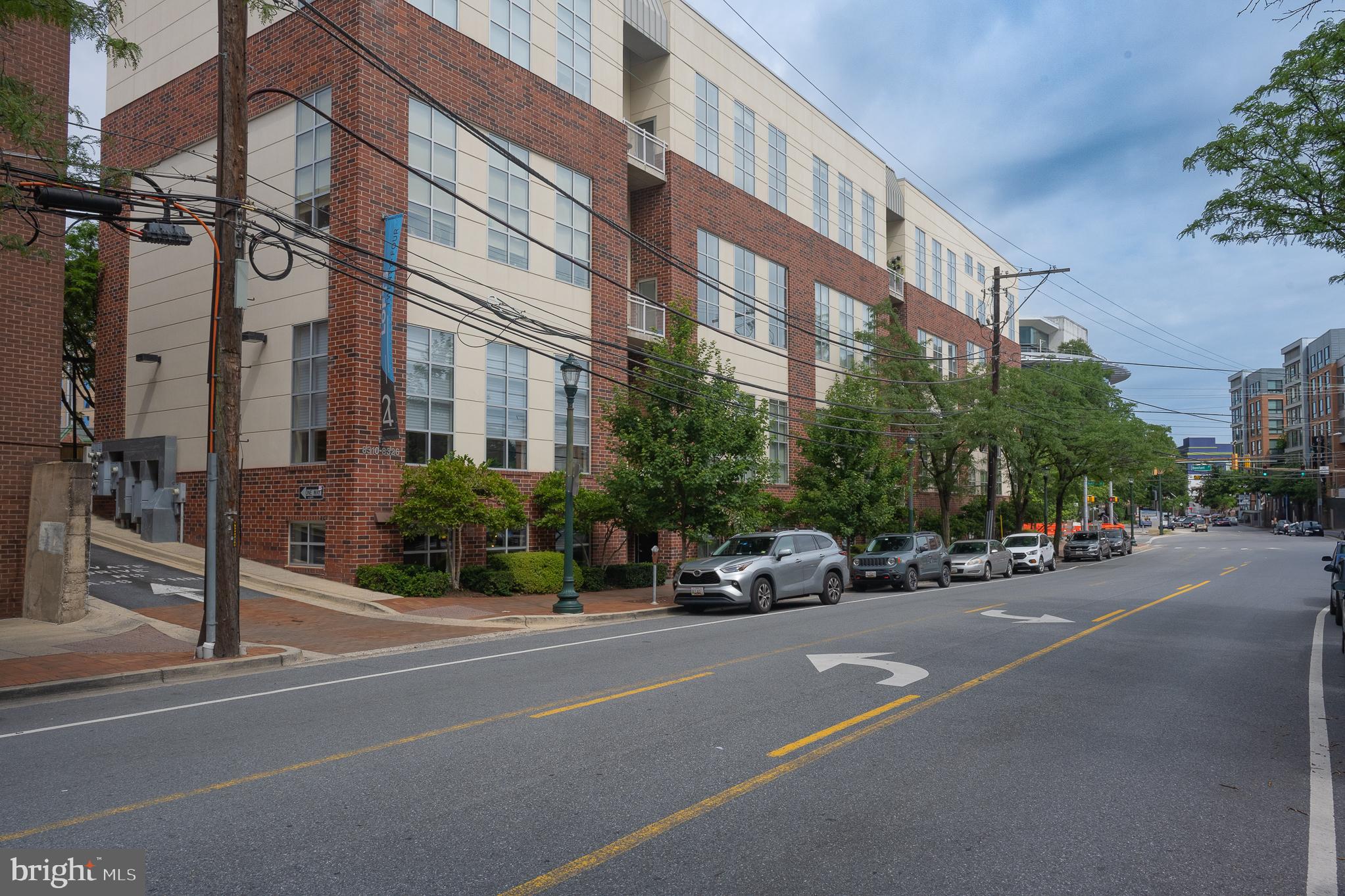 Experience the buzz of Downtown Silver Spring every day from this bright and effortlessly stylish 2 BR/1.5 BA loft at 8310 Fenton St #A in the boutique Lofts 24 building. Offering high ceilings with exposed ductwork, a modern designer ceiling fan, sleek lighting fixtures, and rich Brazilian cherry hardwood floors throughout. The open layout centers around a gourmet kitchen—granite counters, stainless steel appliances, under-cabinet lighting, and a sociable breakfast bar. Enjoy the luxury of in-unit laundry, a powder room, and a shared full bath with an upgraded high-efficiency commode. Engineered for comfort, this unit remains naturally temperate year‑round, boosted by a new HeatPump (May 2025) and a recent water heater. Engineered for silence—inside, you'll forget you're even in the middle of downtown. Dual street-level and interior entrances add an unexpected touch of convenience and privacy. But this isn’t just a home—it’s a ticket to a vibrant, walkable urban life: stroll to Red Line Metro, the soon-to-come Purple Line, Whole Foods, landmark venues like AFI Silver Theatre and The Fillmore, Indie cinemas, and the Civic Plaza. Relish global flavors at 150+ restaurants, sip brews in neighborhood pubs, explore rotating art installations and festivals (including the annual Jazz Fest), visit landmark parks like Acorn Park, or try your swing at nearby Sligo or Northwest Branch trails and golf courses—plus hidden gems like the National Museum of Health & Medicine and the Trolley Museum—all within leisurely reach! Parking spots are also available nearby—Come experience elevated urban living in a neighborhood that blends culture, convenience, and nonstop energy!