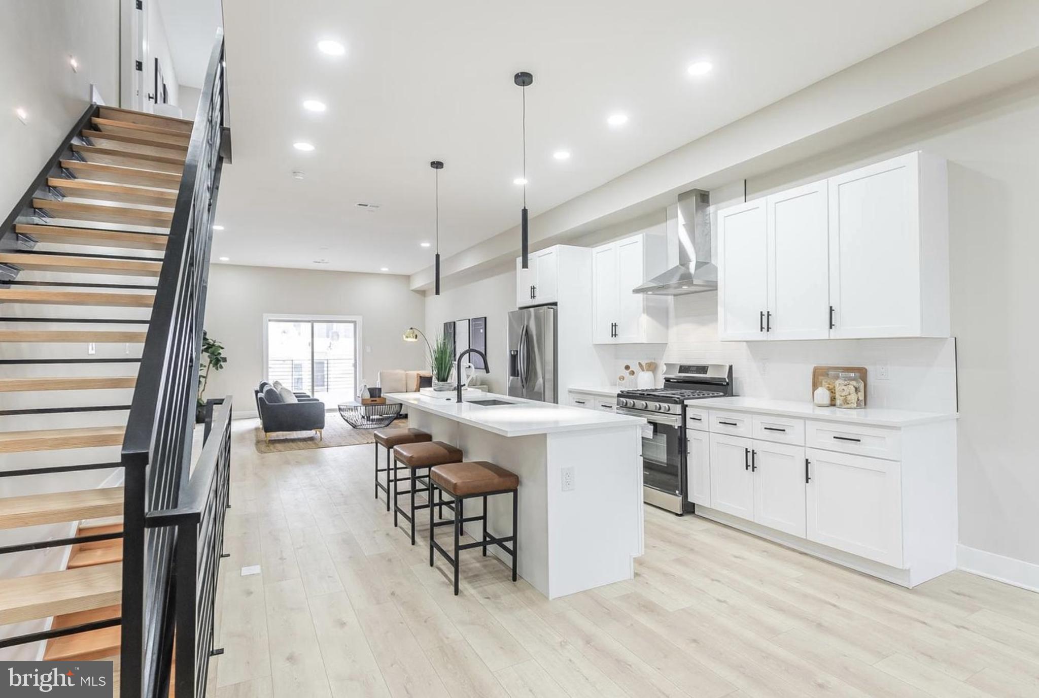 Welcome to 3229 Mercer Street, a luxurious 3-bedroom, 3 full-bath home with private garage parking, located in the heart of Port Richmond. Upon entering, you'll find a generously sized bedroom on the first floor featuring an en-suite bathroom. This level also provides access to your private garage, as well as a fully finished basement that can serve as convenient additional living space or extra storage. Head upstairs to the main living area—an expansive open-concept space featuring wide-plank hardwood floors, soaring 10-foot ceilings, and abundant natural light. The true chef’s kitchen boasts a large center island with a breakfast bar and custom pendant lighting, Samsung stainless steel appliances (including a dishwasher and built-in microwave), and ample soft-close cabinetry. The dedicated dining area and spacious living room flow seamlessly to a large private balcony through sliding glass doors—perfect for indoor-outdoor living. Follow the floating staircase, accentuated by custom lighting, to the upper level. Here, you'll find the luxurious primary suite and a third bedroom. The spacious primary suite offers dual closets, plenty of room for a king-size bed, and a spa-like en-suite bathroom. Finally, take in 360-degree views of the city from the rooftop deck—an ideal space for entertaining guests and watching summer fireworks.