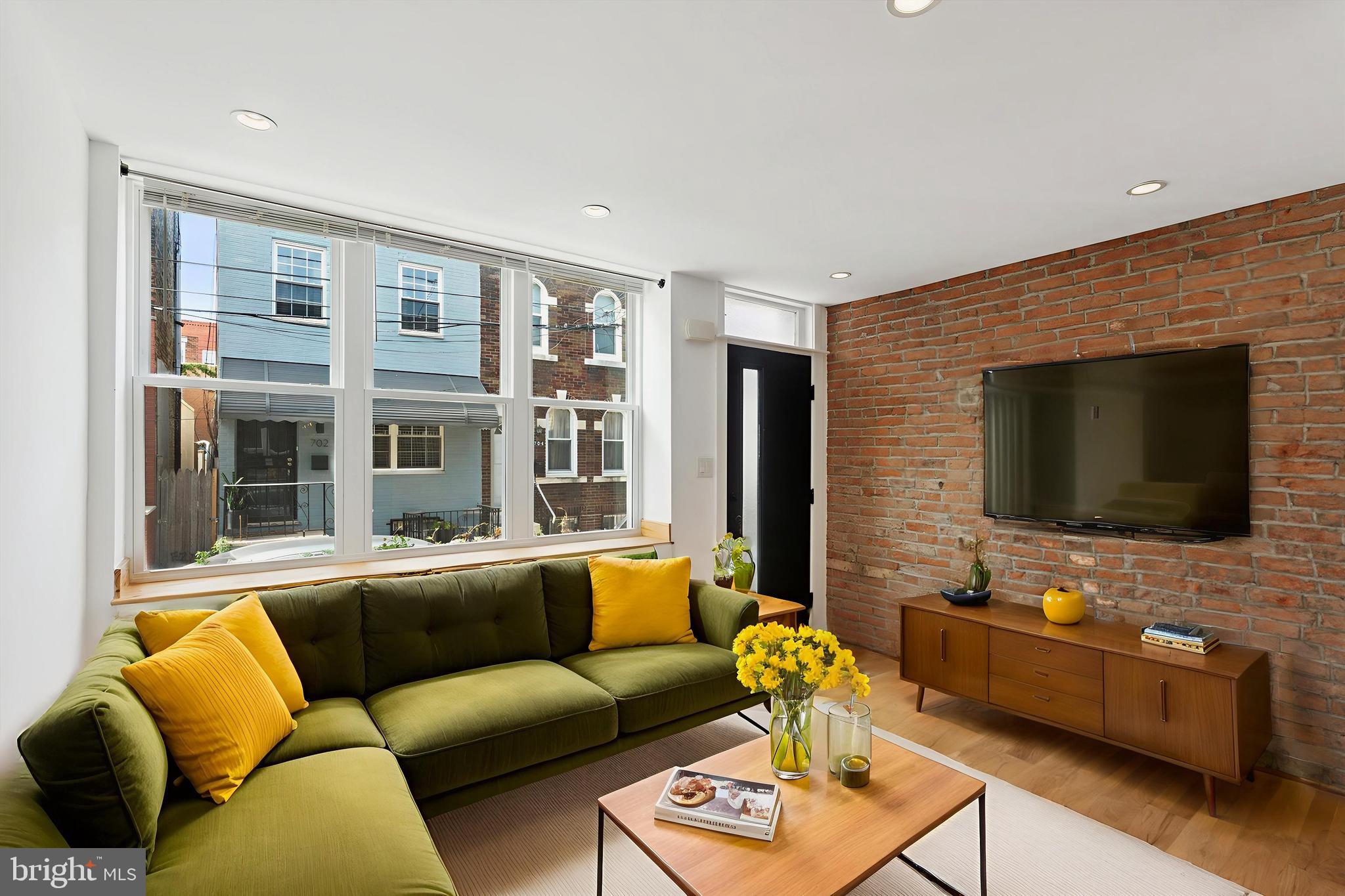 Tucked away in the sought-after East Passyunk Crossing neighborhood, this beautifully maintained home features 2 bedrooms, 1.5 bathrooms, and a private outdoor area. Step inside to discover a sun-filled living room highlighted by exposed brick and large front windows that flood the space with light. The kitchen is thoughtfully designed with sleek stainless steel appliances, central island perfect for entertaining, and pantry offering generous storage for all your cooking essentials. The main level also includes a convenient powder room, coat closet, and direct access to the rear yard via the kitchen. Upstairs, you'll find two well-appointed bedrooms, each equipped with double closets​ with built-in lighting and ceiling fans. A full bath separates the bedrooms, with a washer and dryer nearby for everyday ease. Natural light pours in from the skylight above, brightening the hallway​ with custom railings. The basement is fully waterproofed and provides storage space along with street-level egress​ via brand new bilco doors for added practicality. Central air keeps the home comfortable year-round. Enjoy the unbeatable location just steps from the vibrant offerings of East Passyunk Ave and the Bok Building. Don't miss the opportunity to see this move-in-ready gem - schedule your tour today!