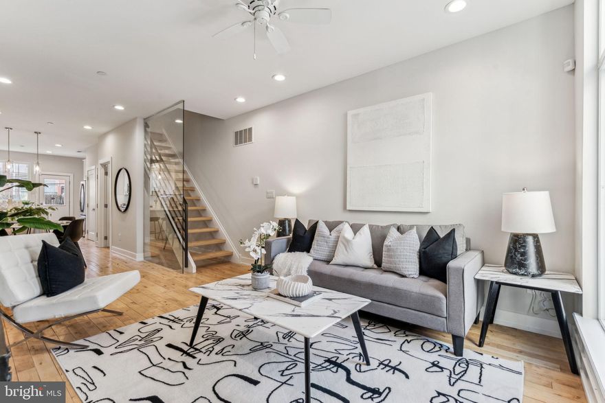 Introducing 1335 N. 30th Street! This immaculately maintained, five year old home impresses immediately upon entry with oversized windows, hardwood floors, and floating stairs with glass wall. Amply apportioned main level with plenty of space for living, dining, and food prep in kitchen. Coat closet at center of the home. Pantry in kitchen. White, quartz countertops, white shaker cabinets with soft close doors, plenty of food storage as well. Large rear patio extends the main level outside. Perfect for outdoor cooking and dining. Back inside, floating stairs lead to the second level. On the second floor, you quickly realize how much bigger this home is than the typical Philadelphia row home. Oversized bedrooms at front and back with large windows. Great closets for storage. Central second floor bathroom with shower/tub as well. The third floor features a large primary bedroom suite with walkthrough closet and charming primary bathroom. The first of two roof decks is accessible from this level. Climb to the upper roof deck and enjoy stunning views of the neighborhood and city. Fully finished basement with 4th bedroom, laundry, half bath, and den. Convenient to Center City Philadelphia, I-76, and Fairmount Park. Schedule your private showing today!