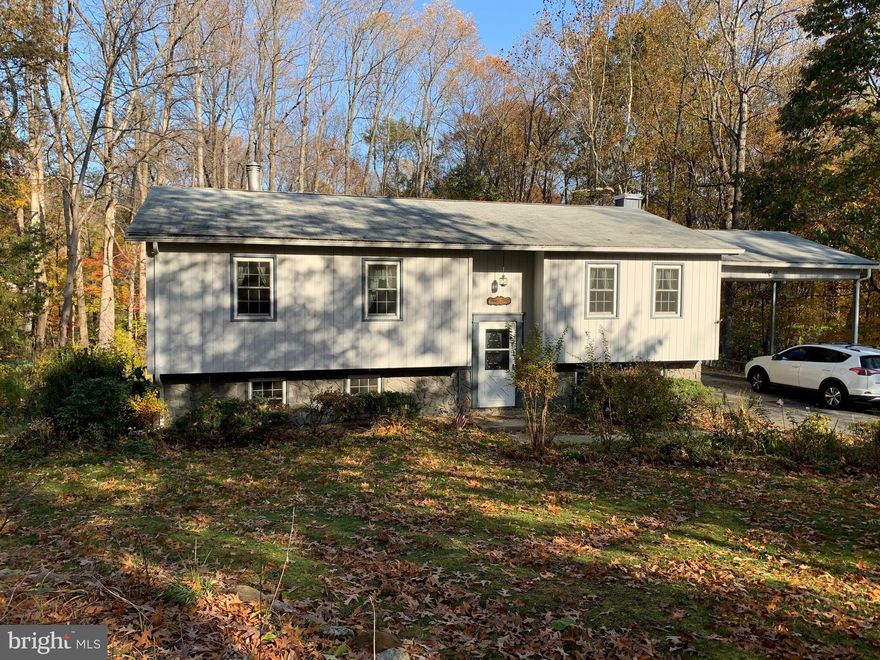 Charming SFH in a wooded community on about 1.5 acres.  Nicely landscaped with lots of privacy.  Large Carport attached.  4 BRs and 3 full baths, a large family room in the basement with a gas fireplace.  Good size deck off of the dining room that looks down on the spacious backyard with a shed.  New well and private septic tank installed in the last few years.  Close to a major artery to Washington DC.