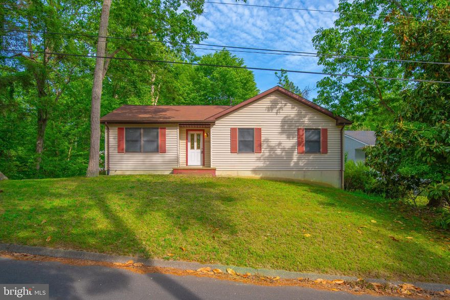 Nestled on a double lot and backing to a serene tree line, this 3-bedroom, 2-bathroom Lusby home is a sanctuary of tranquility and space. The 1,158-square-foot interior leads to an unfinished basement, providing a blank canvas with a rough-in for a third bathroom—tailor this area to suit your needs. Step outside to the deck and enjoy the natural seclusion offered by your fenced backyard. A 2018 roof update offers reassurance of quality, while the community amenities—beaches, lake, golf course, basketball court, garden area, and playground—enrich this home's desirability for those seeking an active, nature-oriented lifestyle.