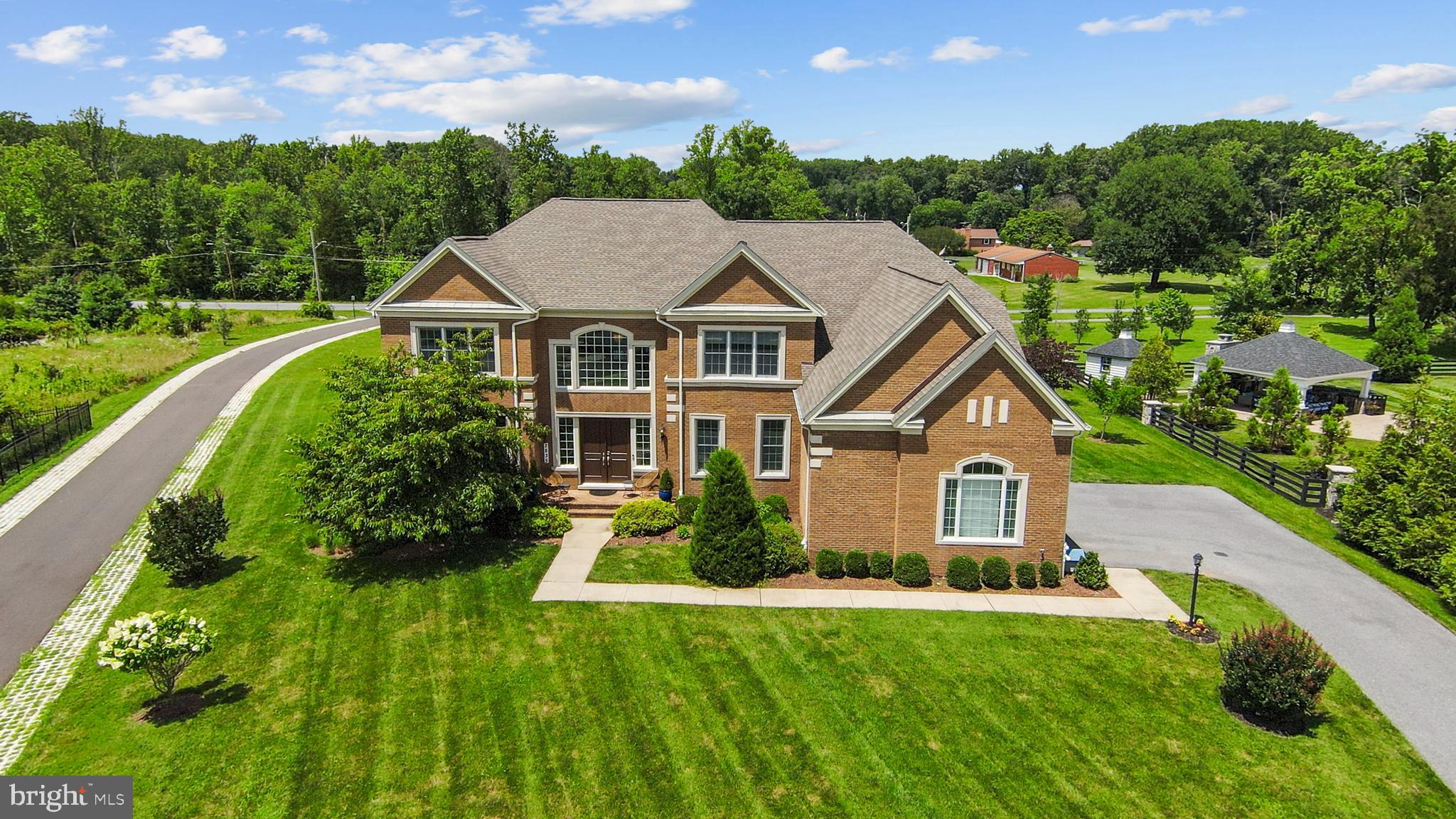 Rarely Available in the Coveted Trotters Glen Community – A Custom Toll Brothers Masterpiece
Welcome to the pinnacle of luxury living—this extraordinary custom-built Toll Brothers Weatherstone model is nestled in prestigious Trotters Glen, one of the area's most sought-after communities. Perfectly situated in a prime, commuter-friendly location, this stately residence boasts nearly 8,800 square feet of refined design, modern comfort, and impeccable craftsmanship.
From the moment you arrive, you’re greeted by stunning curb appeal, enhanced by additional brick siding for a more distinguished facade. Step into the grand two-story foyer, where a sweeping dual staircase sets an unforgettable tone—ushering you into a home designed to impress.
Rich, gleaming hardwood floors flow throughout the home, creating a warm and luxurious foundation for everyday living. The graceful curved staircases and upper landings are accentuated with elegant black wrought iron balusters, infusing classic style and architectural interest into the home's modern decor.
Crafted for both luxurious everyday living and effortless entertaining, the home features soaring 9-foot ceilings, a sophisticated formal living room, a generous dining room, and a dramatic two-story family room anchored by a fireplace adorned with custom designer stonework. At the heart of the home lies the gourmet chef’s kitchen, equipped with top-of-the-line Monogram appliances, a six-burner cooktop with griddle, farmhouse sink, expansive granite countertops, and custom cabinetry—perfect for culinary creations and casual gatherings alike. Enjoy serene views from the sun-drenched breakfast room and sunroom, both ideal for relaxed mornings or elegant afternoon tea.
The kitchen flows seamlessly into a large, custom-designed mudroom with built-in cabinetry—thoughtfully crafted to elevate both form and function. This versatile space features two additional exits: one to the side yard and another providing direct access to the side-load garage, enhancing everyday convenience and connectivity.
Upstairs, retreat to the lavish primary suite, a private sanctuary featuring a spa-inspired bath with premium finishes, an oversized walk-in shower with custom sliding glass doors, and a modern standalone soaking tub—a thoughtful upgrade that enhances both space and luxury. Dual walk-in closets have been customized with premium built-ins, offering abundant storage for even the most discerning wardrobe.
Three additional bedrooms, each with its own en suite bath, ensure comfort and privacy for family and guests.
The newly finished lower level offers a versatile extension of your living space, complete with a full bath and endless possibilities—create a home theater, gym or entertainment lounge tailored to your lifestyle. French doors provide walk up access to the beautifully landscaped backyard.
Outdoors, enjoy over half an acre of manicured lawn, flowering trees, and lush shrubbery. The extra-large, side-load 3-car garage easily accommodates an SUV, your daily driver, and that dream car you’ve worked hard to own—offering convenience and curb appeal in one elegant package.
Every detail in this home has been thoughtfully curated to deliver elevated living in a premier location. Don’t miss the opportunity to own this rare gem in Trotters Glen.