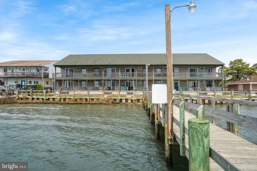 Welcome to your dream getaway! This renovated 2-bedroom, 1-bath condominium in the bay-front Sea Tag building on Chincoteague Island is a slice of paradise. Boasting an open, airy floor plan, the spacious living room is perfect for relaxation. Luxurious LVP flooring sprawls throughout, seamlessly connecting spaces. The eat-in kitchen is a culinary delight with stainless steel appliances, a chic tile backsplash, and sleek new cabinets. Retire to the cozy bedrooms, offering comfort and tranquility. The bathroom is elegantly designed for convenience. Enjoy relaxing on the covered front porch or rear covered deck, offering expansive bay and lighthouse views—truly breathtaking! The community pier is a haven for fishing enthusiasts, featuring fish cleaning stations and floating docks. This property serves as a wonderful second home or an outstanding investment opportunity. Don't miss out on owning a piece of Chincoteague's charm, where every day feels like a vacation!