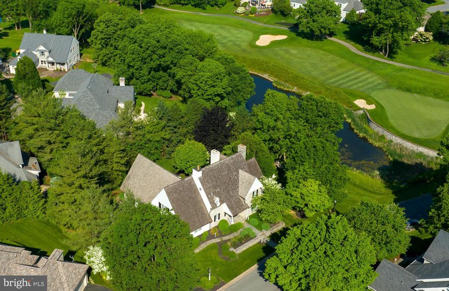Located in Bent Creek Country Club in Manheim Township stands this luxurious and exquisite home overlooking scenic water and golf course views. The foyer is welcoming and unveils each large stylish room. Just off the foyer is a formal dining room with crown molding, chair rail, and large windows that let in natural light and overlook the front of the home. Next is the incredible and central living room, ideal for entertaining guests. The living room contains hardwood floors, gas fireplace, built-in speakers, and built-in entertainment center. Working from home is easy with a home office that has an access panel to the living room's entertainment center for convenient set up. An added bonus is the venting system that could turn the office into a cigar lounge. A unique and stunning room is the sitting room with fireplace and large windows that overlook the pond views. The sitting room also has access to the patio. The gourmet kitchen is magnificent with center island, large marble countertop, stainless steel appliances. Cooking and baking are a breeze with cooktop, oven, refrigerator drawers. A set of French doors opens into the walk-in pantry with built-in shelves, counters, microwave and oven. At the end of the pantry is a nook that could be another little study for doing projects or homework. Off the 2-car garage with custom doors is a mudroom with access to the side entrance and laundry room complete with walk-in closet, cabinets, sink and countertop. Plus, there is access to the attached 1-car garage with custom doors. As you ascend the stairs to the upper level you will find a landing and hall with hardwood floors and crown molding overlooking the foyer's stunning chandelier. This level hosts 3 bedrooms and 2 full baths. At the top of the stairs is a walk-in closet for extra storage. The owner's suite is spacious and has its own large walk-in closet with center island. The owner's private bath is amazing with hardwood floors, walk-in shower, and soaking tub. A large window over the tub lets lots of warm and bright natural light in. The next bedroom is spacious and the bedroom at the end of the hall is open, has a walk-in closet and a bonus room. The private patio is an ideal space for entertaining guests or relaxing with a fireplace and built-in Lynx grill. Other outstanding features include an unfinished lower level with walkout, central vac and extra storage space. Pristine landscaping throughout the exterior with stone walls, stone steps, patio, and covered porches.